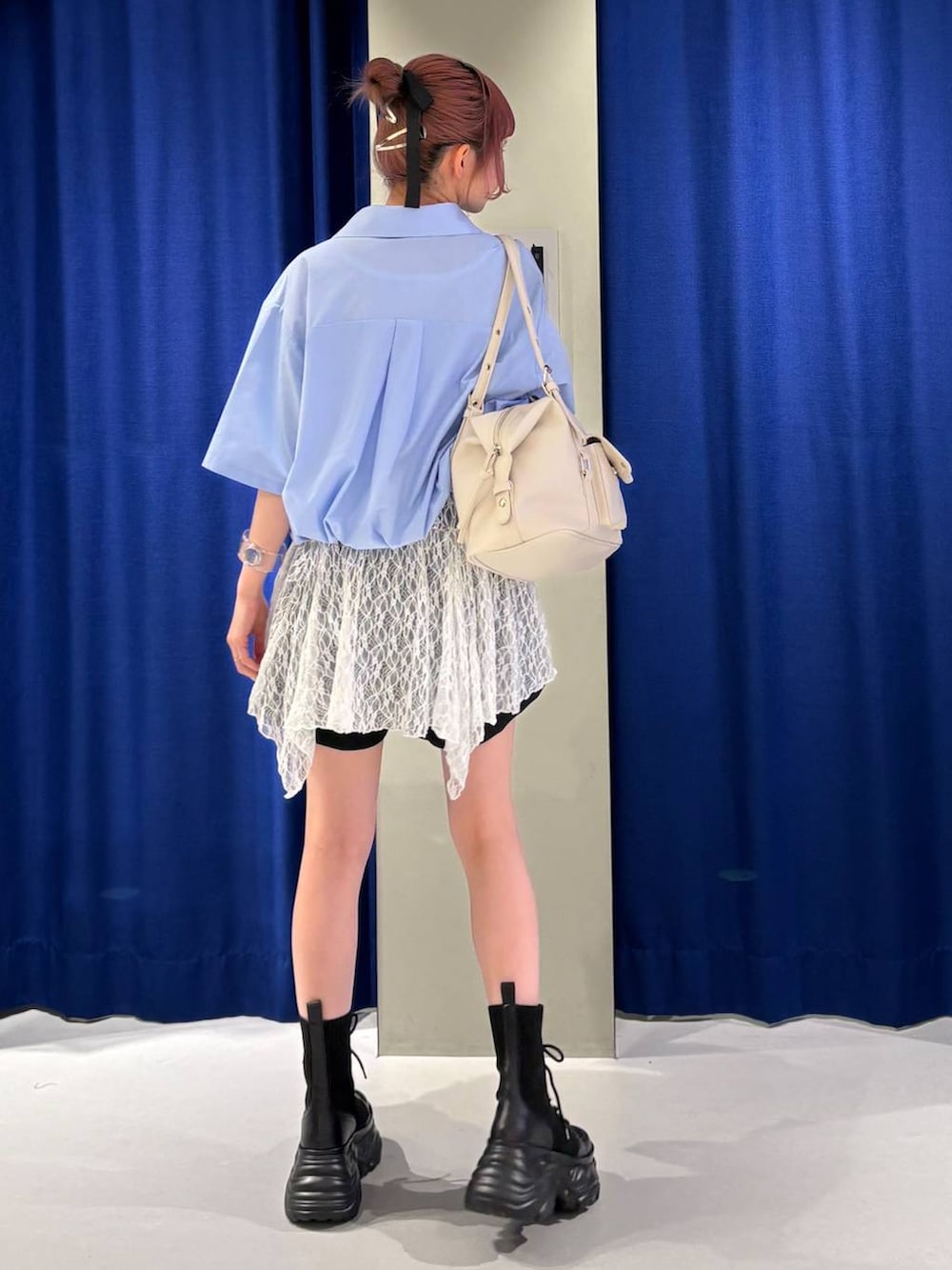 ブラック系のブーツ、ブラック系のその他パンツ、ホワイト系のボストンバッグを着用したレディースの春コーディネートの3枚目の写真