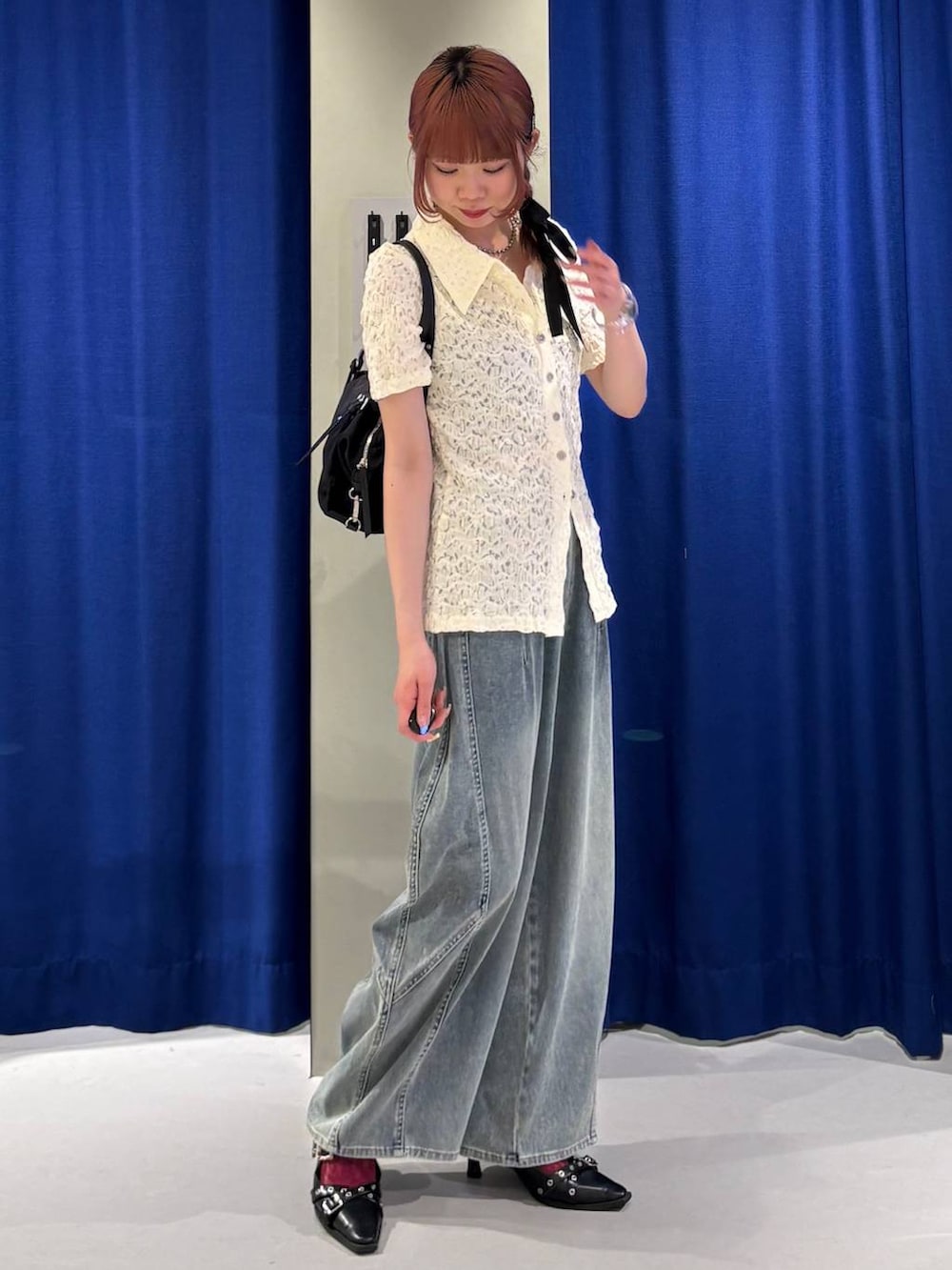 ブラック系のキャミソール、ブルー系のデニムパンツ、ブラック系のトートバッグを着用したレディースの春コーディネートの2枚目の写真
