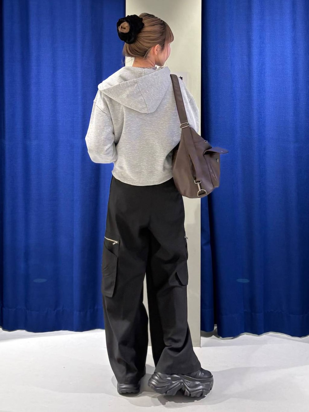 ブラック系のスニーカー、ブラウン系のショルダーバッグ、グレー系のパーカーを着用したレディースの冬コーディネートの3枚目の写真