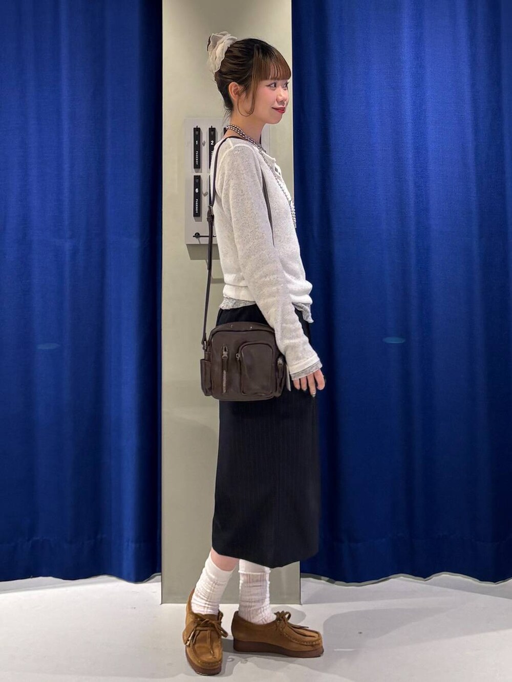ブラウン系のショルダーバッグ、グレー系のTシャツ/カットソー、ホワイト系のTシャツ/カットソーを着用したレディースの春コーディネートの2枚目の写真