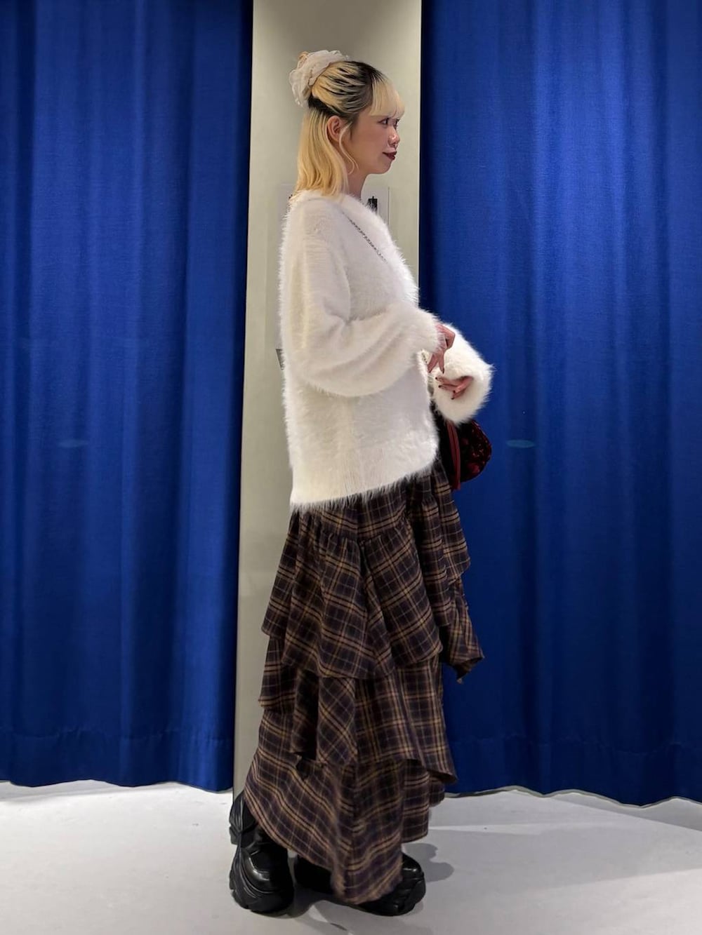 ブラック系のブーツ、ブラウン系のスカート、ホワイト系のニット/セーターを着用したレディースの冬コーディネートの2枚目の写真