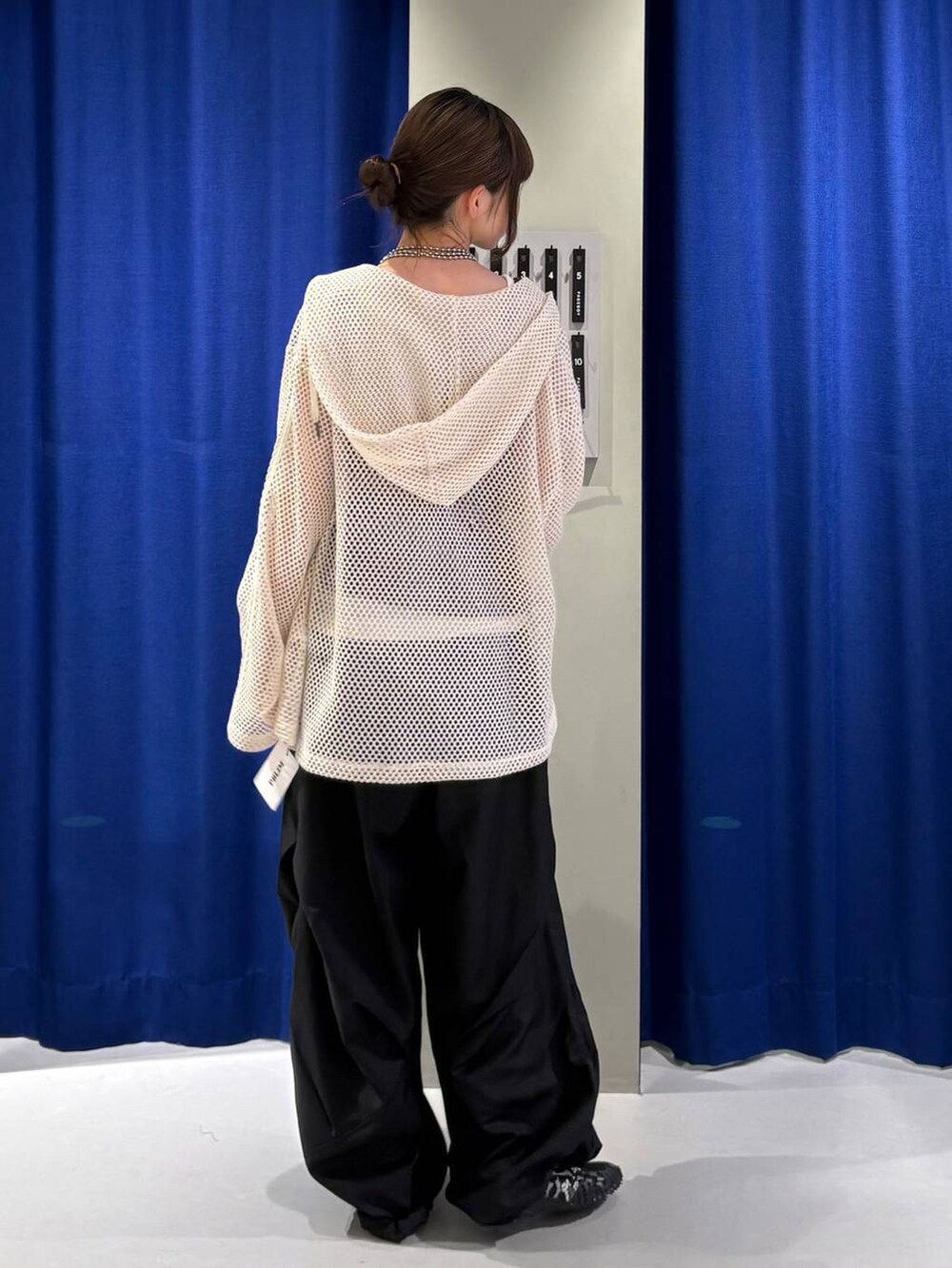 ホワイト系のパーカー、ブラウン系のタンクトップ、ブラック系のスラックスを着用したレディースの夏コーディネートの3枚目の写真
