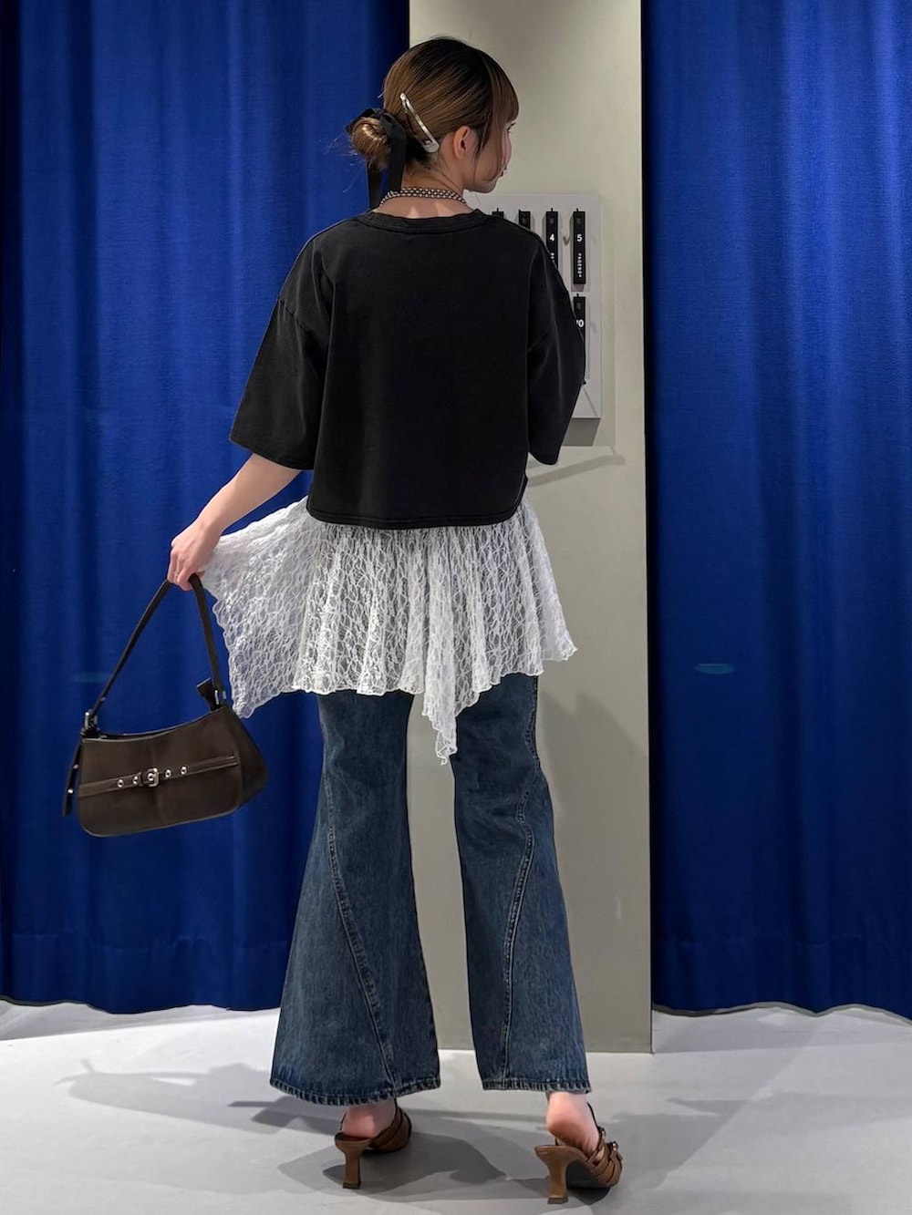 ブルー系のデニムパンツ、ブラウン系のハンドバッグ、グレー系のTシャツ/カットソーを着用したレディースの春コーディネートの3枚目の写真