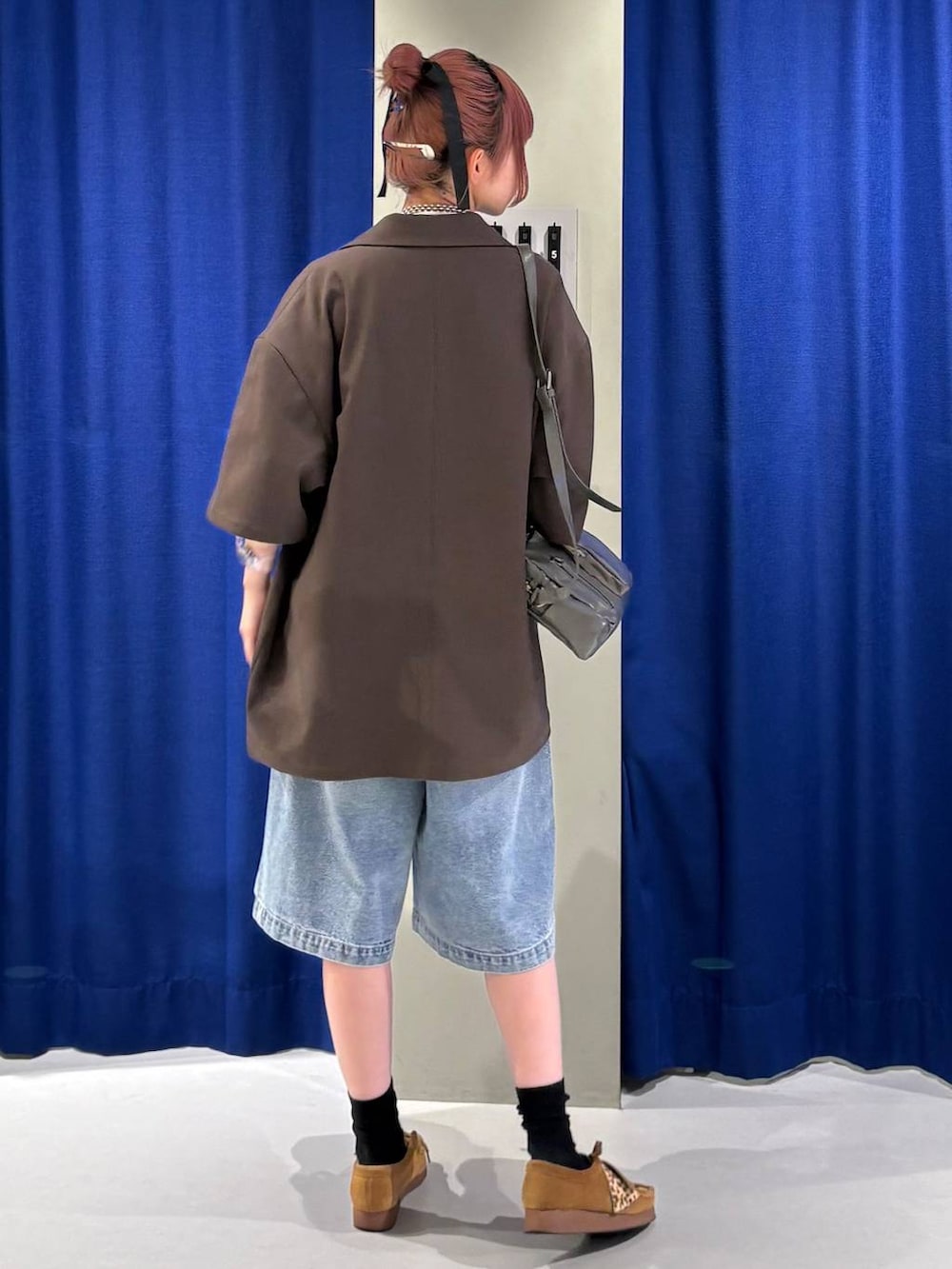 ブルー系のデニムパンツ、グレー系のショルダーバッグ、ホワイト系のTシャツ/カットソーを着用したレディースの春コーディネートの3枚目の写真