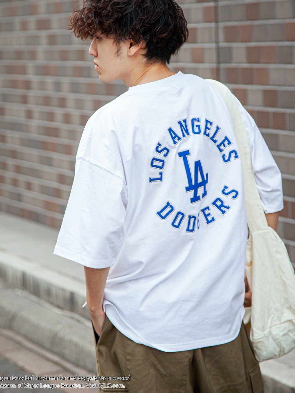 ホワイト系のTシャツ/カットソー、ベージュ系のカーゴパンツ、ホワイト系のショルダーバッグを着用したメンズの春コーディネートの2枚目の写真