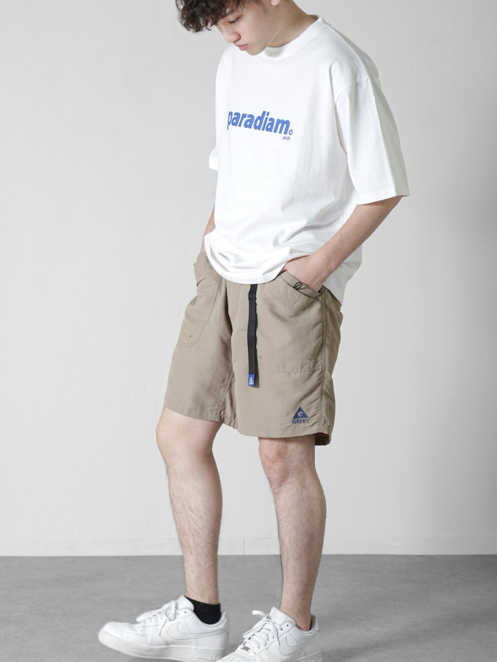 ホワイト系のTシャツ/カットソー、ベージュ系のその他パンツ、ホワイト系のスニーカーを着用したメンズの春コーディネートの2枚目の写真