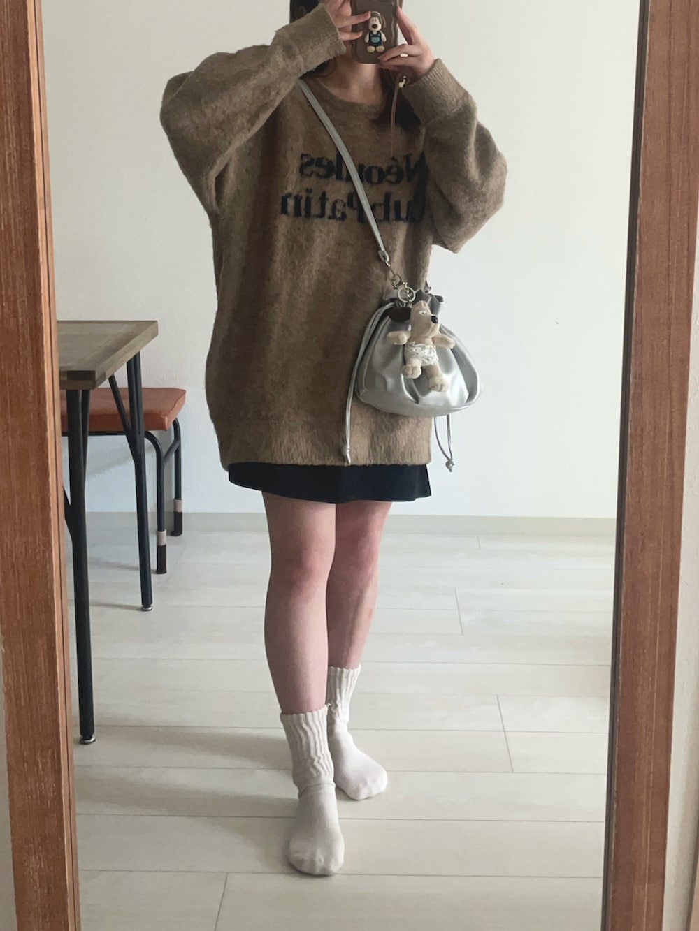 ベージュ系のニット/セーター、ブラック系のスカートを着用したレディースの冬コーディネートの2枚目の写真