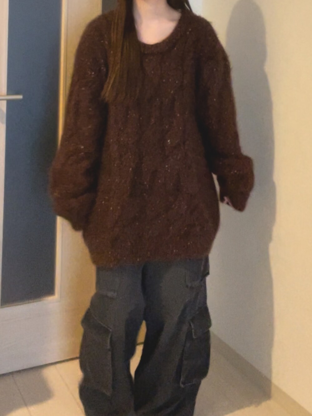 ブラウン系のニット/セーター、ブラック系のデニムパンツを着用したレディースの冬コーディネートの2枚目の写真