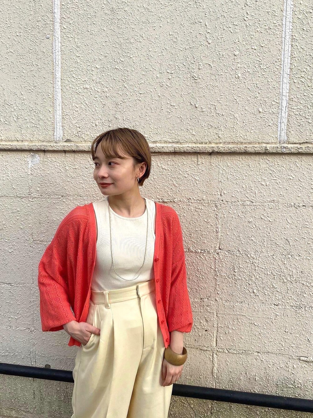 ピンク系のニット/セーター、ホワイト系のその他パンツ、イエロー系のサンダルを着用したレディースの春コーディネートの2枚目の写真