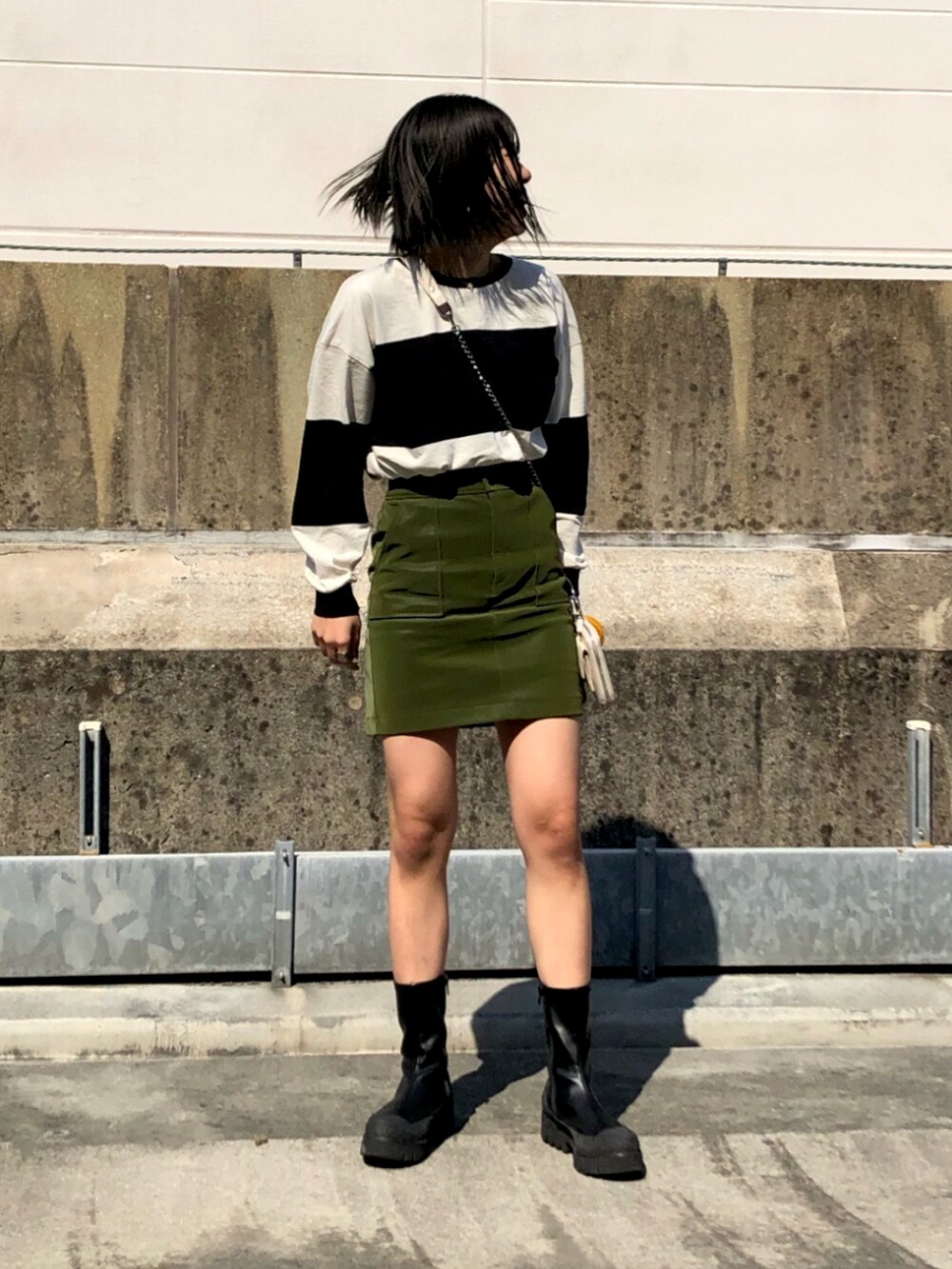 ブラック系のTシャツ/カットソー、ホワイト系のショルダーバッグ、グリーン系のスカートを着用したレディースの冬コーディネートの2枚目の写真