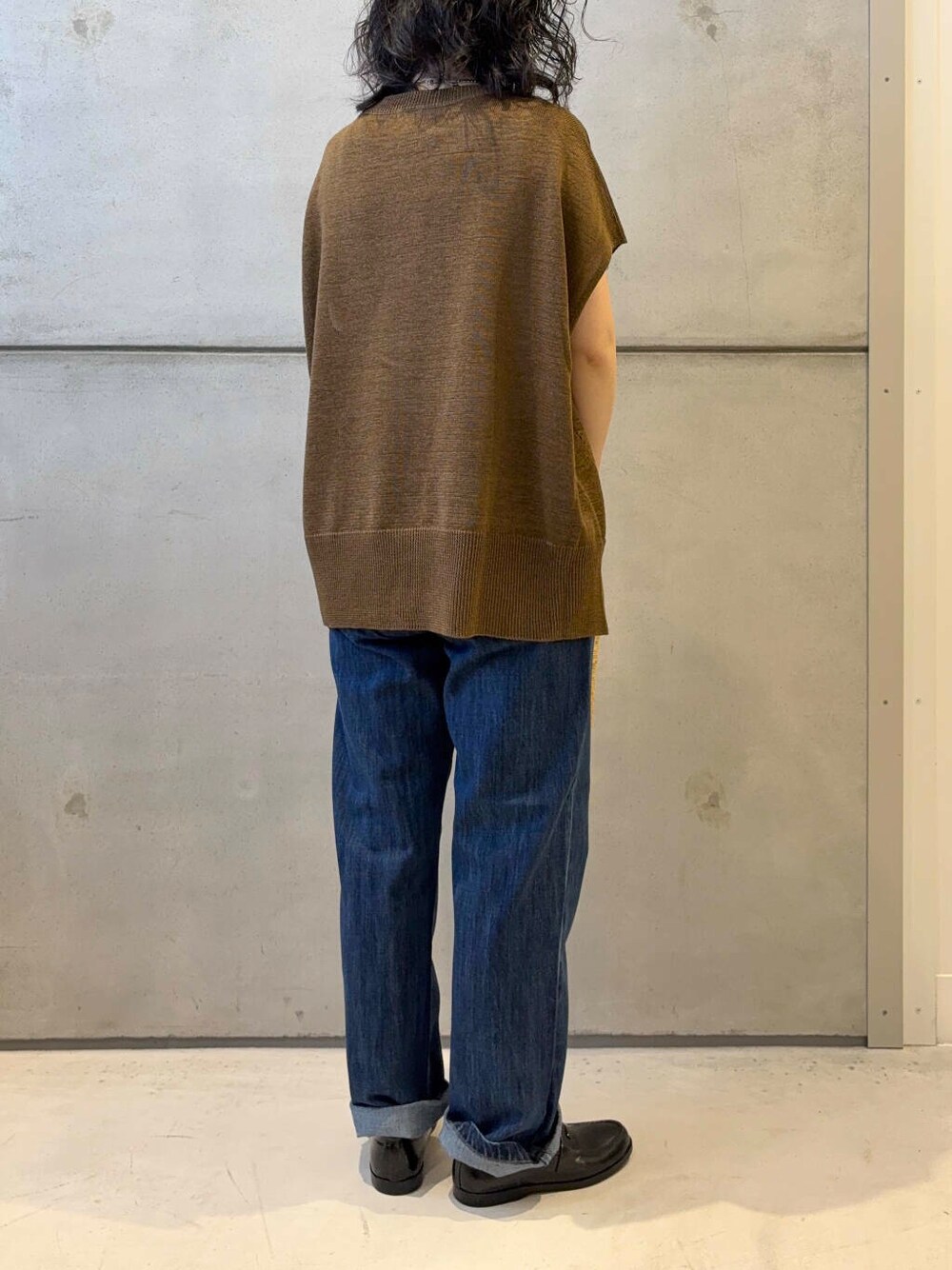 イエロー系のショルダーバッグ、ブルー系のデニムパンツ、ブラウン系のニット/セーターを着用したレディースの夏コーディネートの4枚目の写真