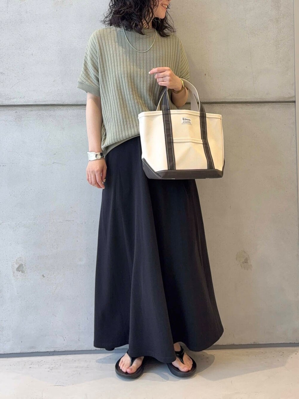 ブラック系のサンダル、ブラック系のスカート、シルバー系のブレスレットを着用したレディースの夏コーディネートの2枚目の写真