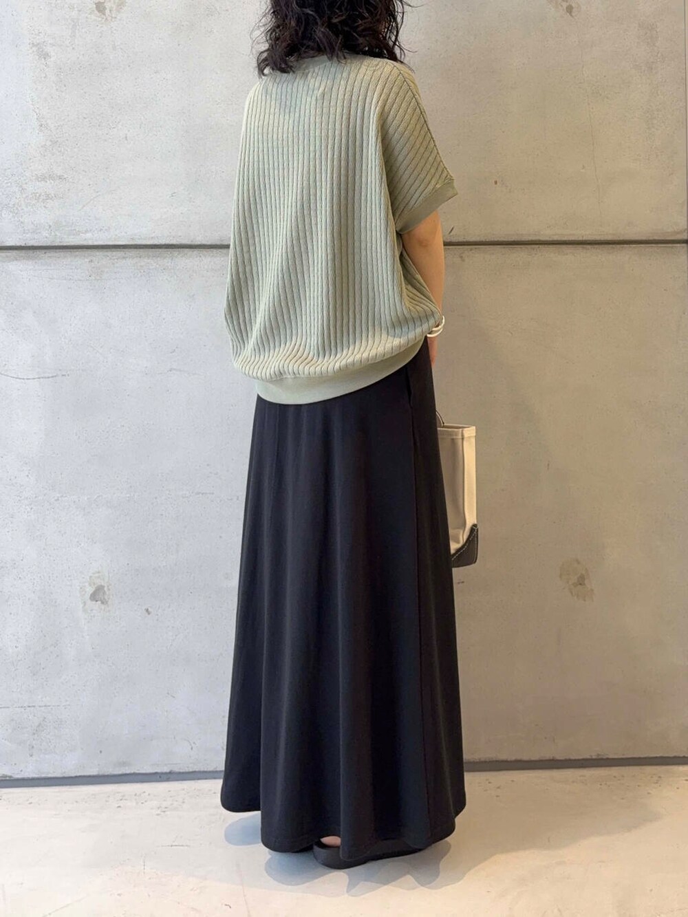 ブラック系のサンダル、ブラック系のスカート、シルバー系のブレスレットを着用したレディースの夏コーディネートの4枚目の写真