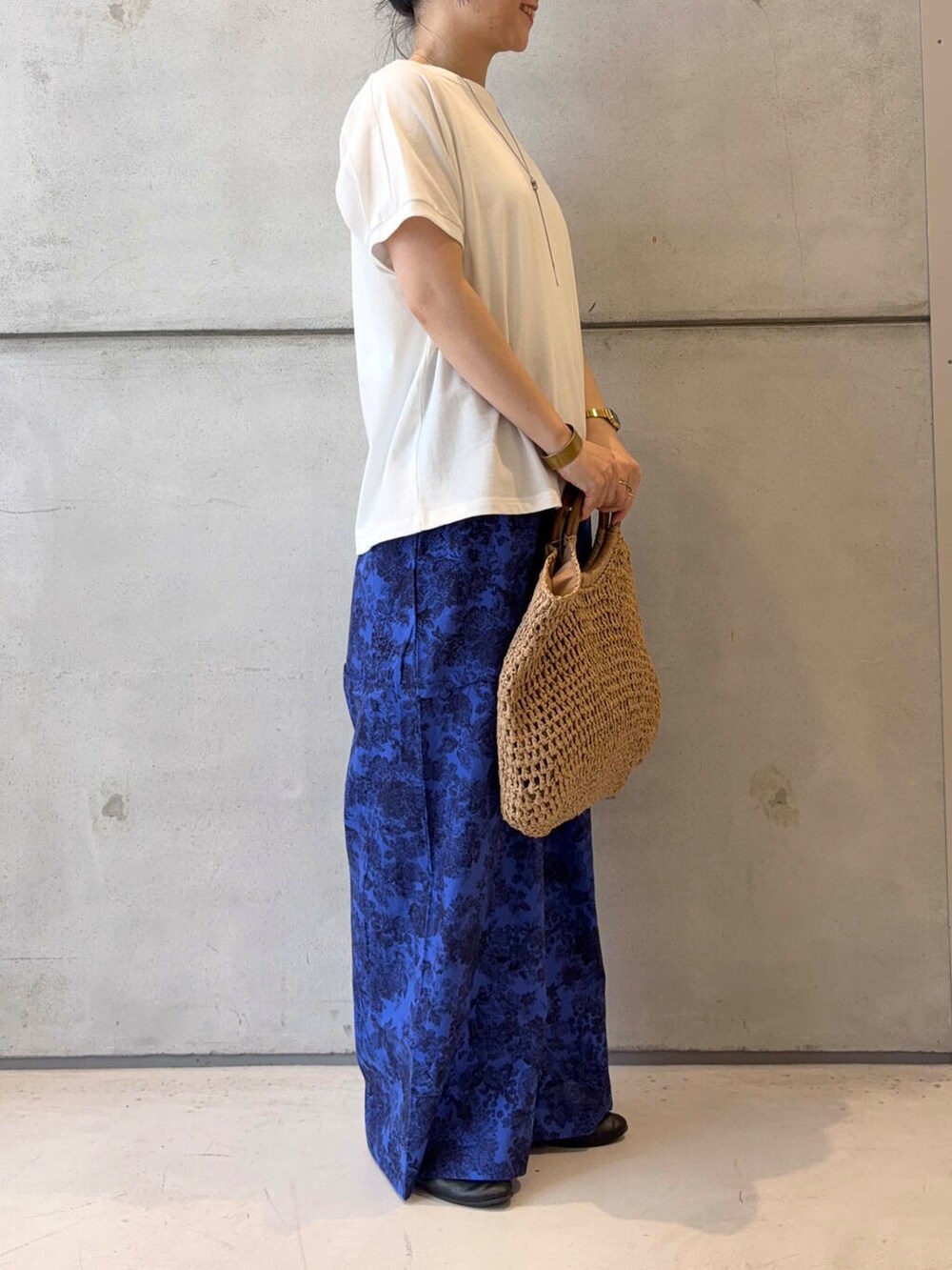 ベージュ系のトートバッグ、ブラック系のパンプス、ホワイト系のTシャツ/カットソーを着用したレディースの夏コーディネートの6枚目の写真