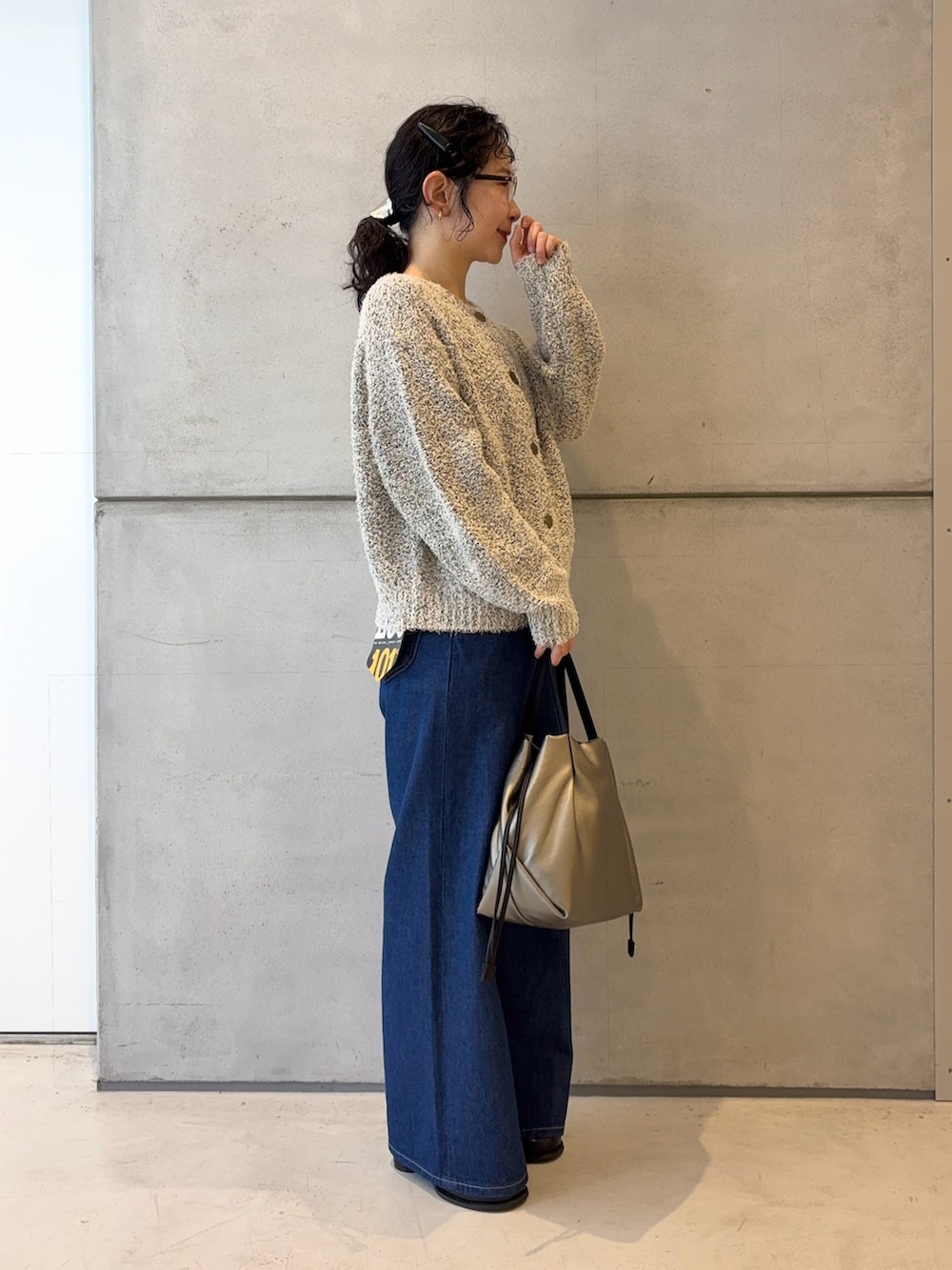 ホワイト系のカーディガン/ボレロ、ブルー系のデニムパンツ、シルバー系のショルダーバッグを着用したレディースの冬コーディネートの3枚目の写真