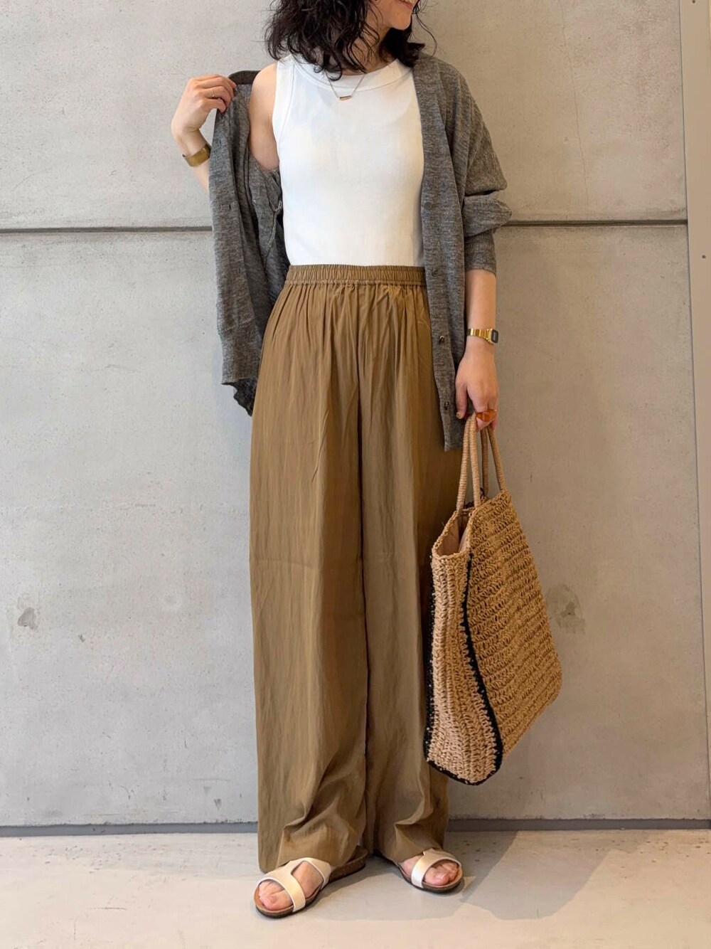 グレー系のカーディガン/ボレロ、ベージュ系のトートバッグ、ホワイト系のタンクトップを着用したレディースの夏コーディネートの3枚目の写真