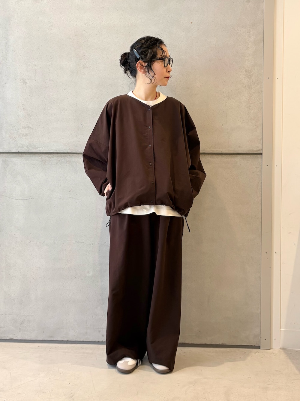 ブラウン系のカーディガン/ボレロ、ブラウン系のその他パンツ、ホワイト系のスニーカーを着用したレディースの春コーディネートの2枚目の写真