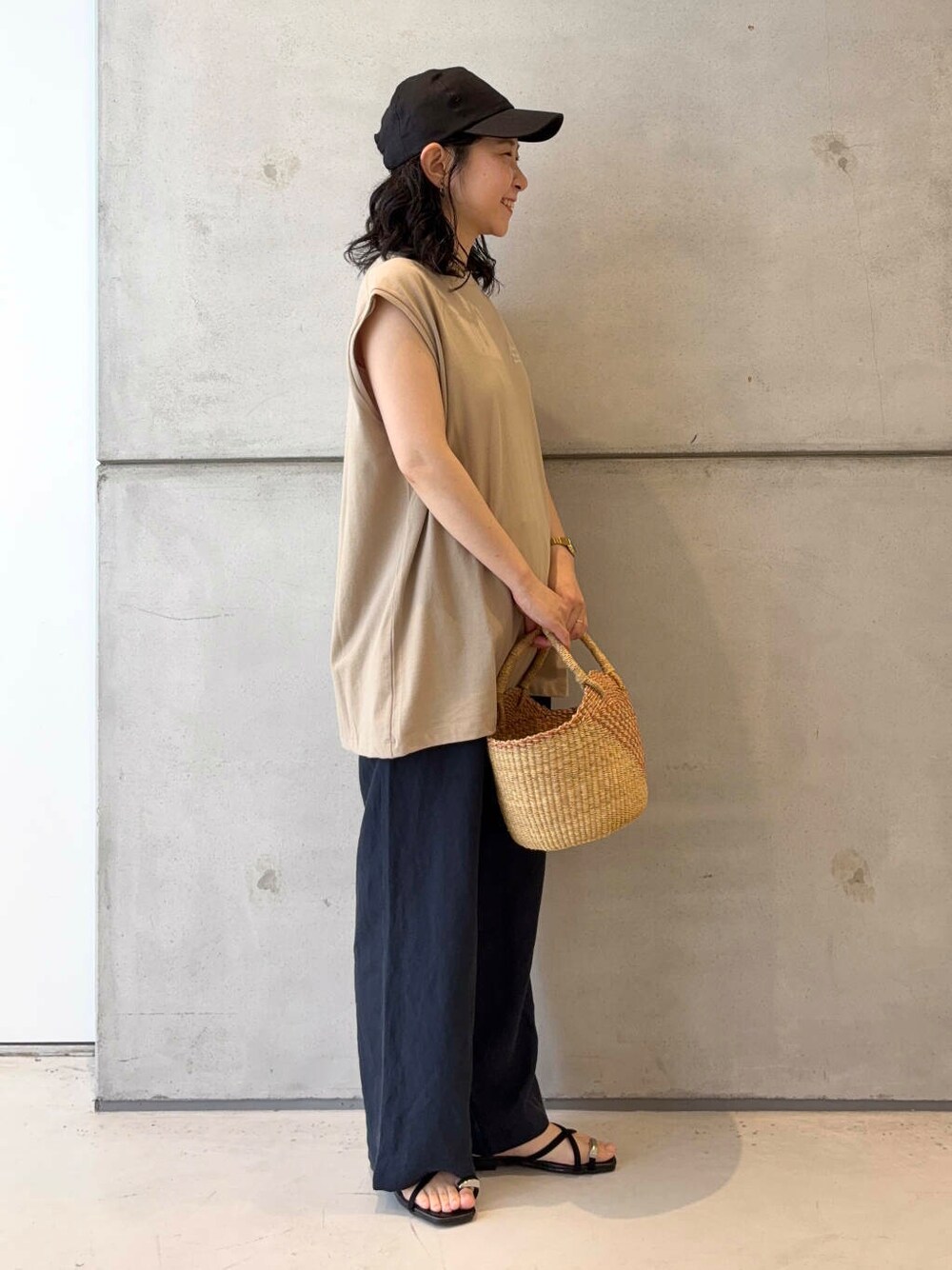 オレンジ系のショルダーバッグ、ベージュ系のTシャツ/カットソー、ブルー系のその他パンツを着用したレディースの夏コーディネートの3枚目の写真