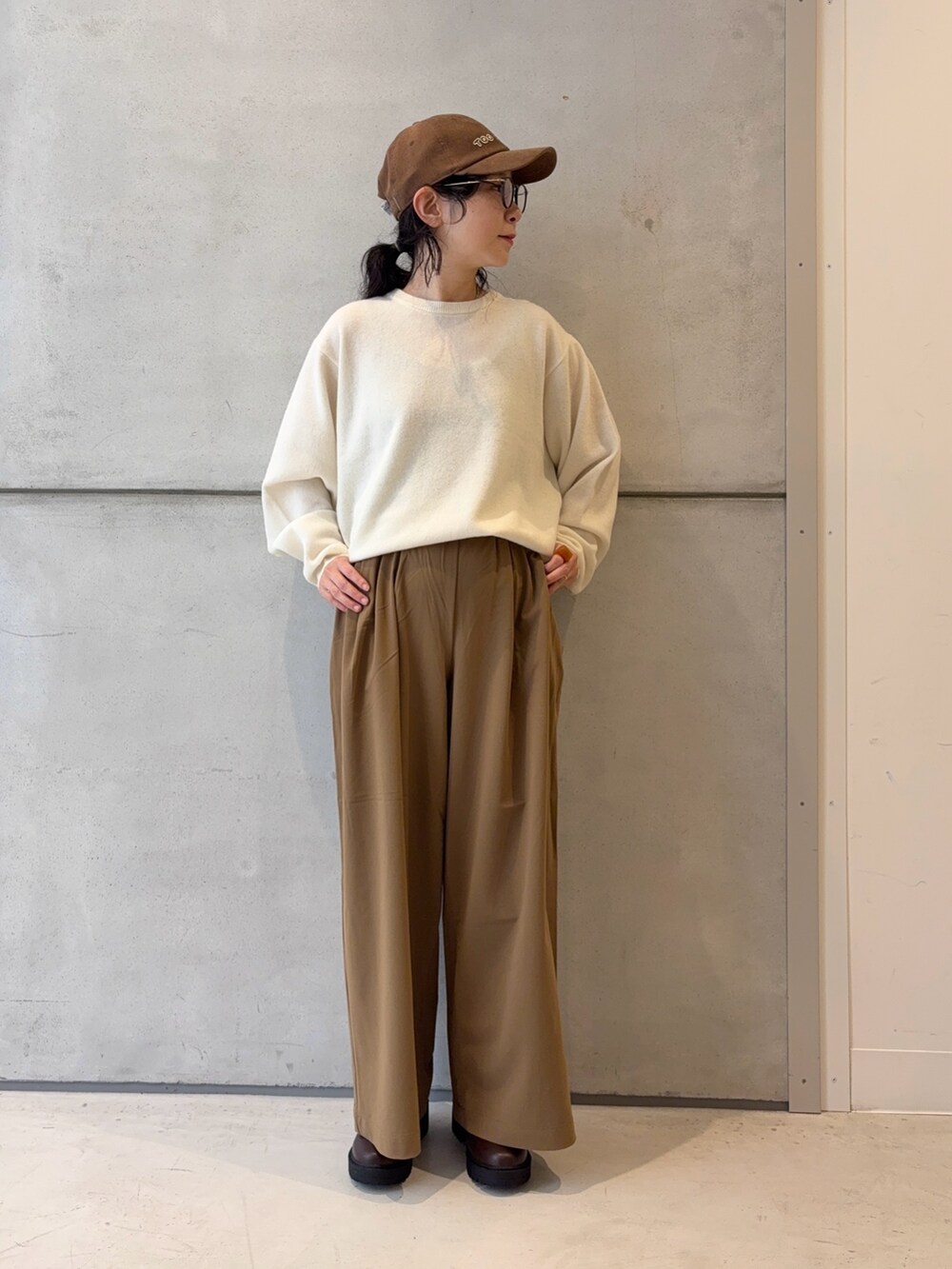 ブラウン系のブーツ、ホワイト系のニット/セーター、イエロー系のその他パンツを着用したレディースの冬コーディネートの6枚目の写真