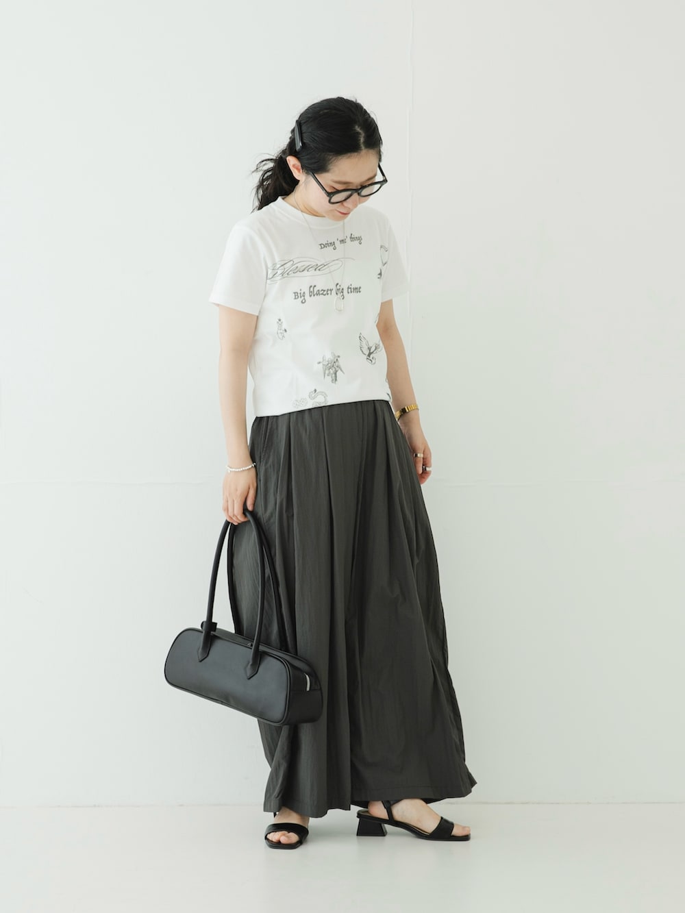 ホワイト系のTシャツ/カットソー、グレー系のその他パンツ、ブラック系のサンダルを着用したレディースの夏コーディネートの2枚目の写真