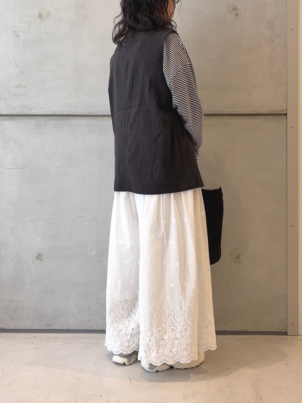 ブラック系のTシャツ/カットソー、ブラック系のその他アウター、ホワイト系のその他パンツを着用したレディースの秋コーディネートの4枚目の写真