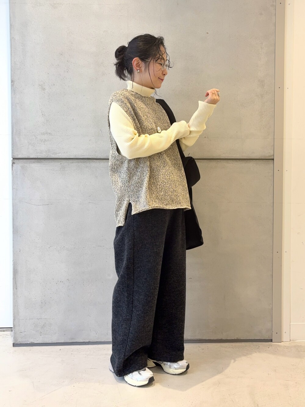 ブラック系のトートバッグ、グレー系のその他パンツ、シルバー系のスニーカーを着用したレディースの冬コーディネートの3枚目の写真