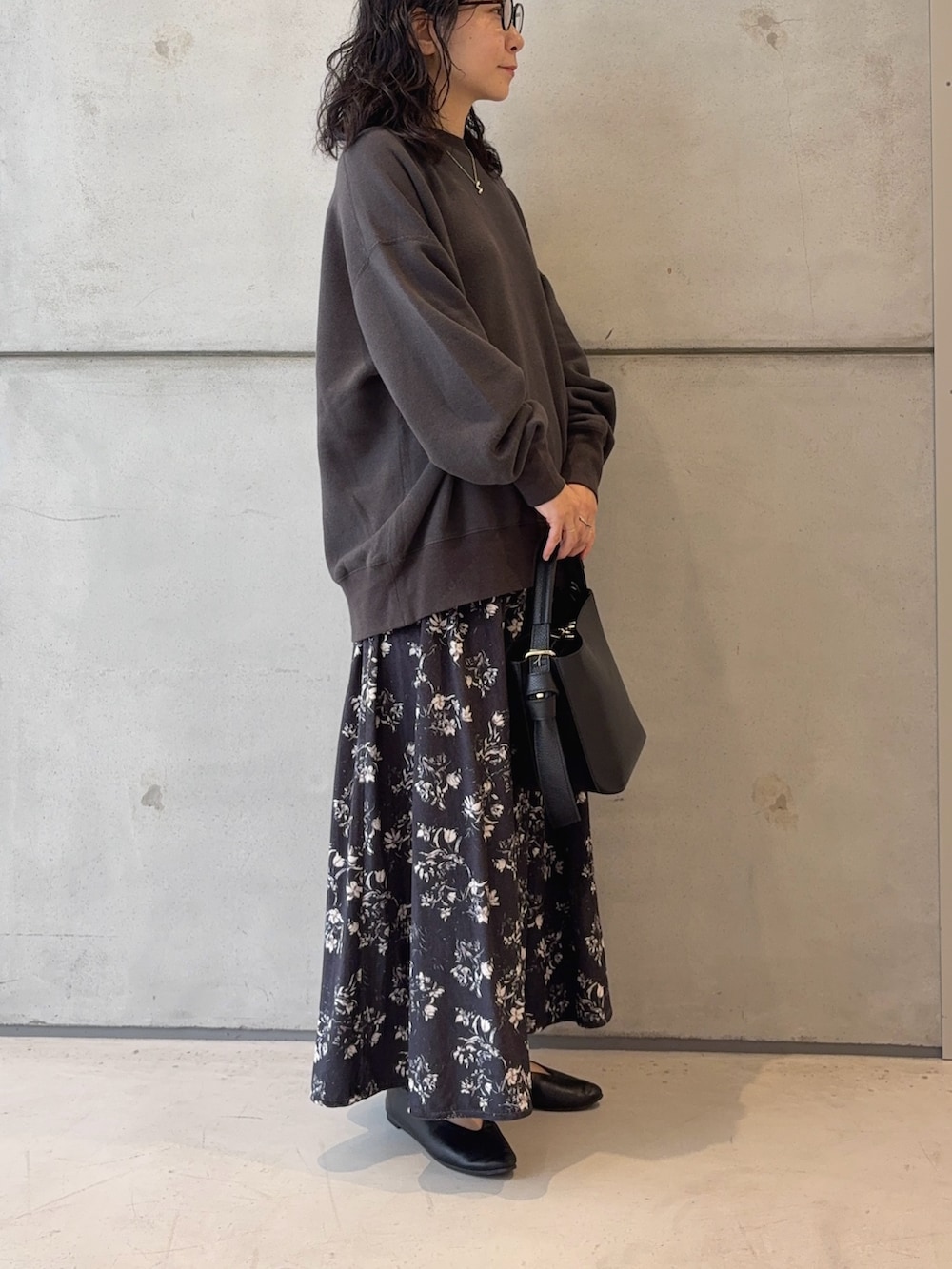 グレー系のスウェット、ブラック系のハンドバッグ、ブラック系のパンプスを着用したレディースの秋コーディネートの3枚目の写真