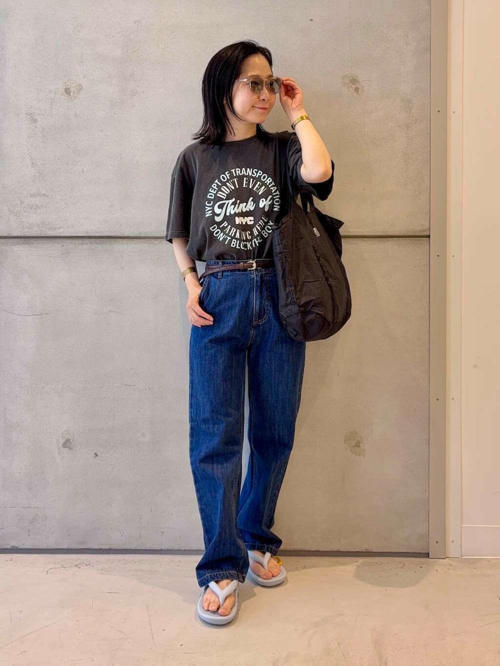 ブルー系のデニムパンツ、グレー系のTシャツ/カットソー、ブラウン系のベルトを着用したレディースの春コーディネートの2枚目の写真