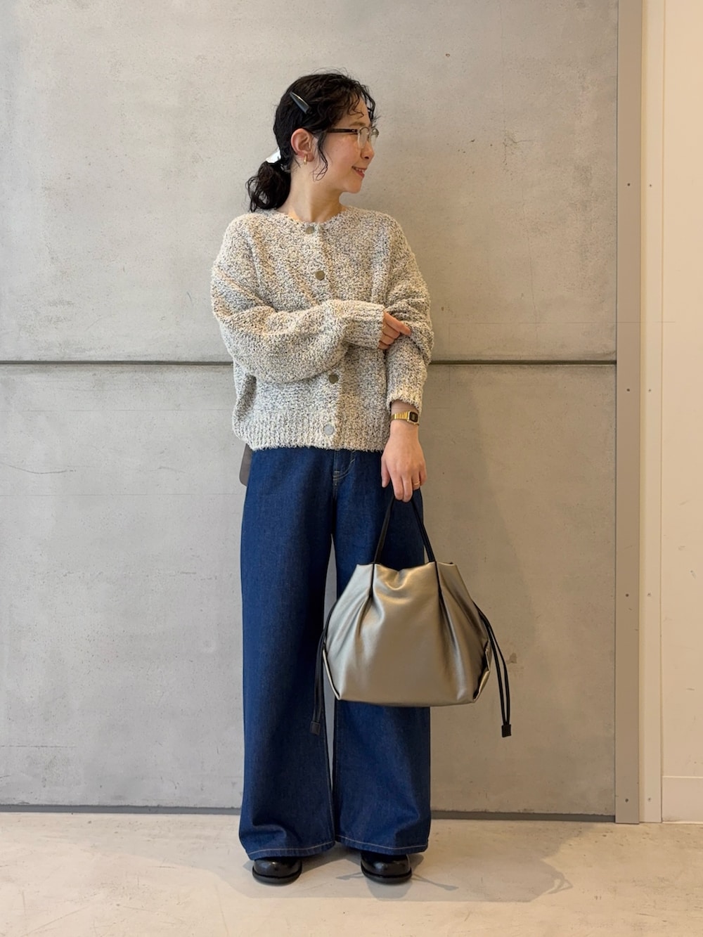 ホワイト系のカーディガン/ボレロ、ブルー系のデニムパンツ、シルバー系のショルダーバッグを着用したレディースの冬コーディネートの2枚目の写真