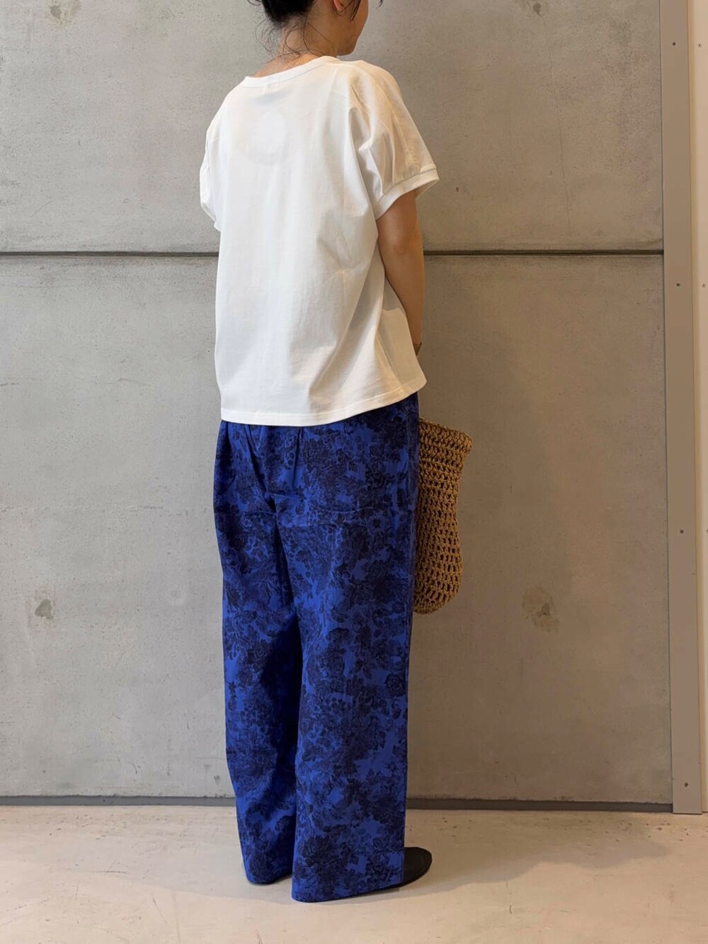 ベージュ系のトートバッグ、ブラック系のパンプス、ホワイト系のTシャツ/カットソーを着用したレディースの夏コーディネートの7枚目の写真