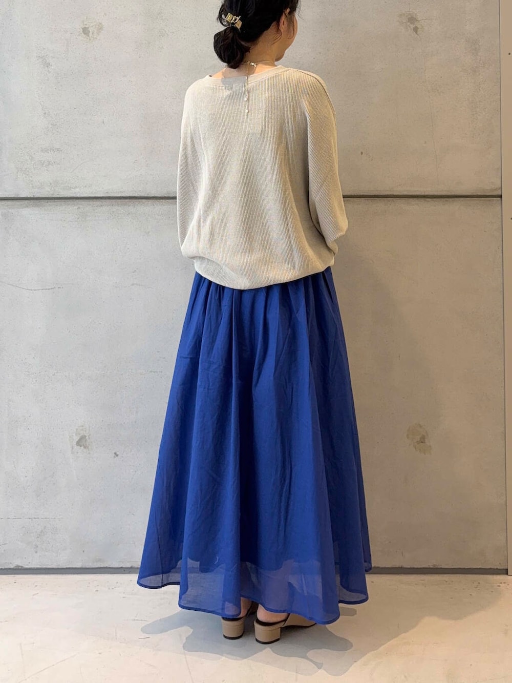 ベージュ系のTシャツ/カットソー、イエロー系のサンダル、ブルー系のスカートを着用したレディースの夏コーディネートの4枚目の写真