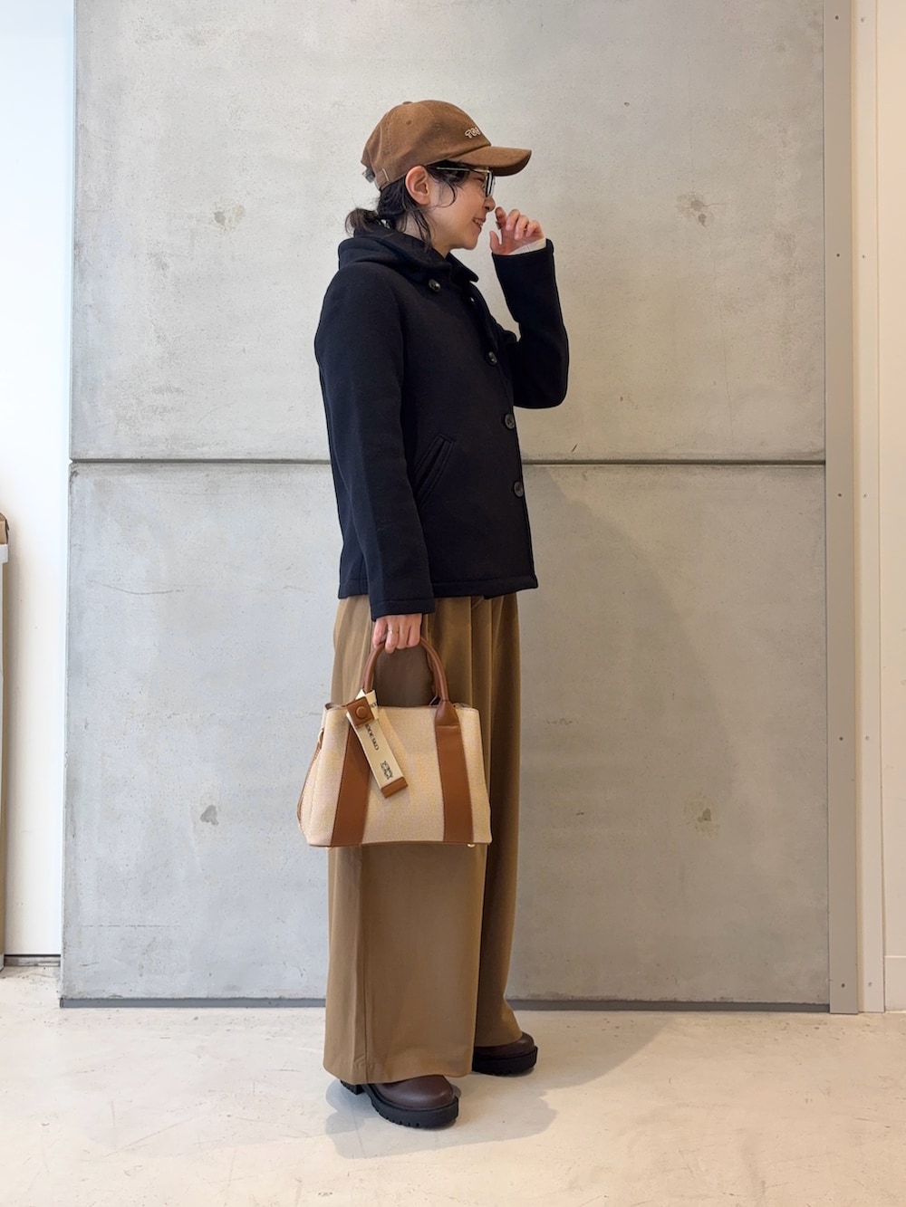 ブラウン系のブーツ、ホワイト系のニット/セーター、イエロー系のその他パンツを着用したレディースの冬コーディネートの4枚目の写真