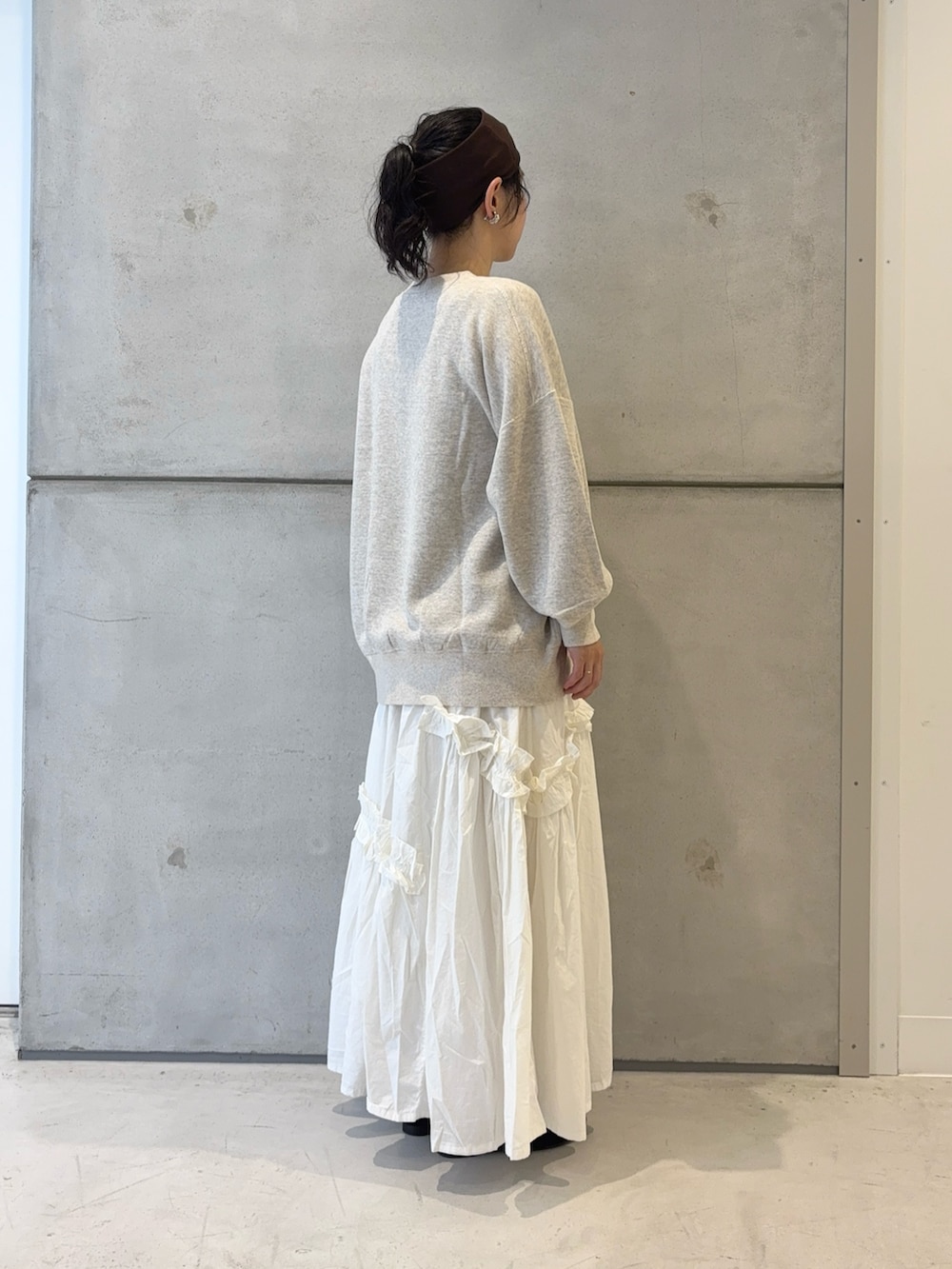 ブラック系のローファー、ホワイト系のスカート、ベージュ系のスウェットを着用したレディースの秋コーディネートの3枚目の写真