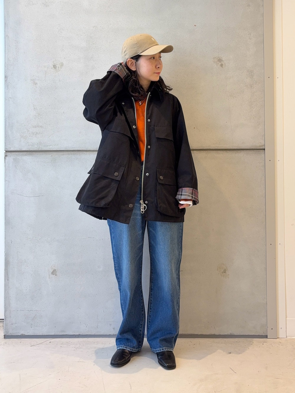 ブラック系のブーツ、ブルー系のデニムパンツ、ブラック系のその他アウターを着用したレディースの秋コーディネートの2枚目の写真
