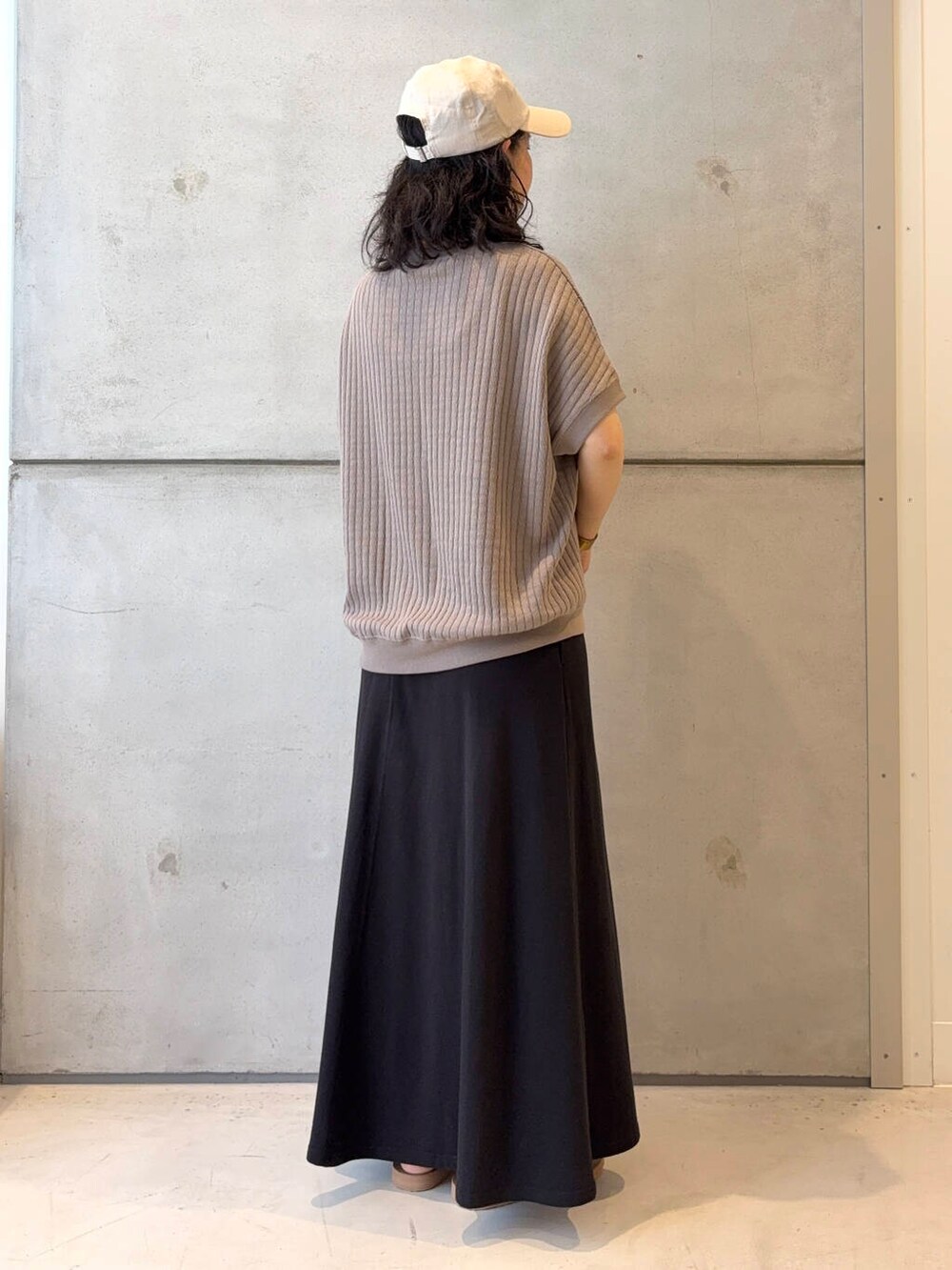 ベージュ系のトートバッグ、ブラック系のスカート、ブラウン系のサンダルを着用したレディースの夏コーディネートの4枚目の写真