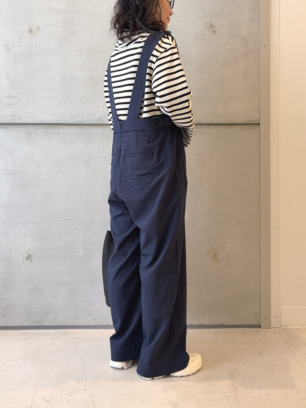 ブラック系のトートバッグ、ホワイト系のTシャツ/カットソー、ホワイト系のスニーカーを着用したレディースの秋コーディネートの4枚目の写真