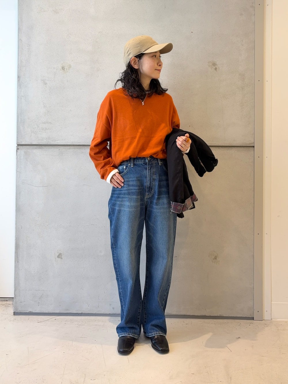 ブラック系のブーツ、ブルー系のデニムパンツ、ブラック系のその他アウターを着用したレディースの秋コーディネートの5枚目の写真
