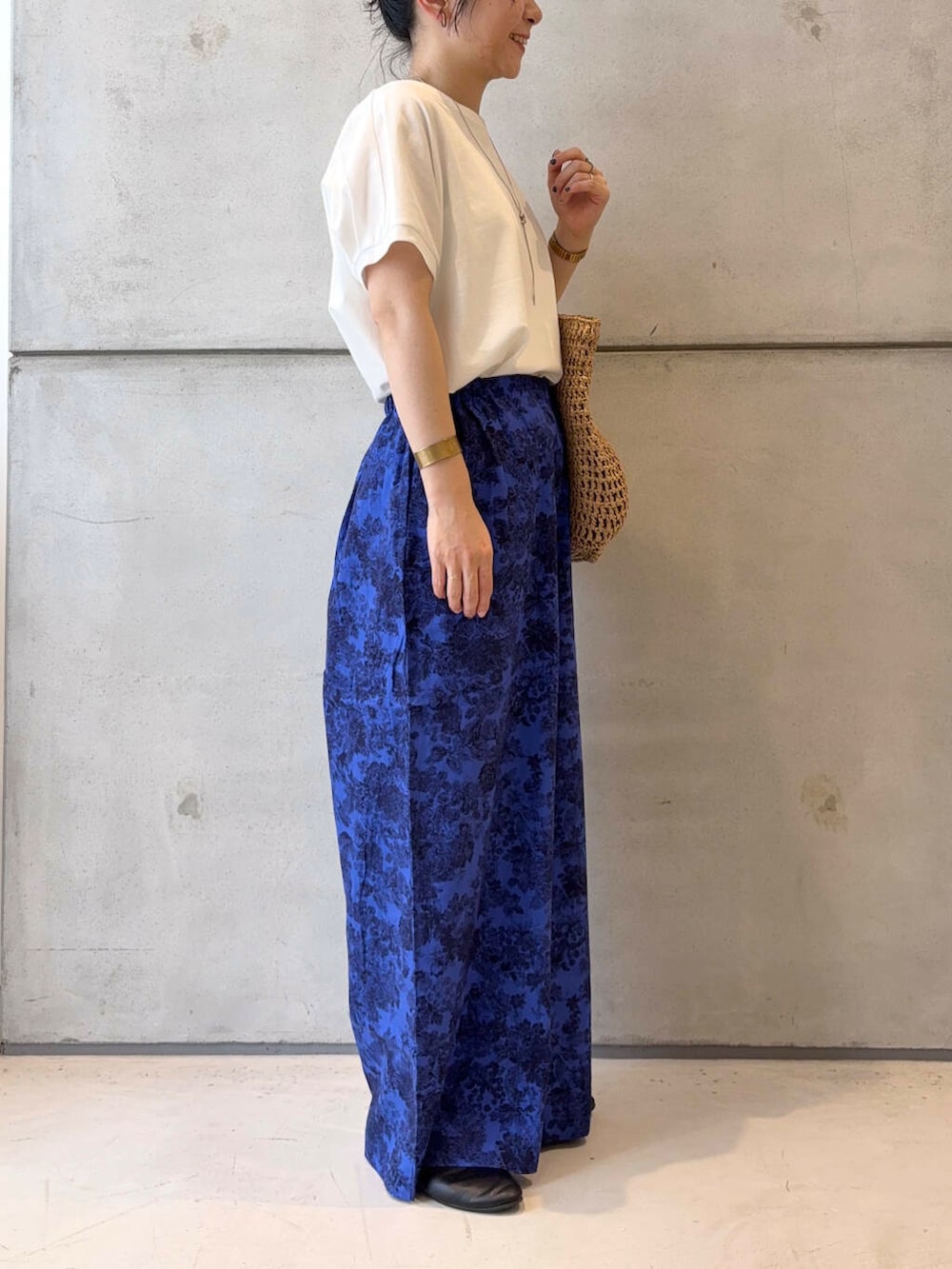 ベージュ系のトートバッグ、ブラック系のパンプス、ホワイト系のTシャツ/カットソーを着用したレディースの夏コーディネートの3枚目の写真