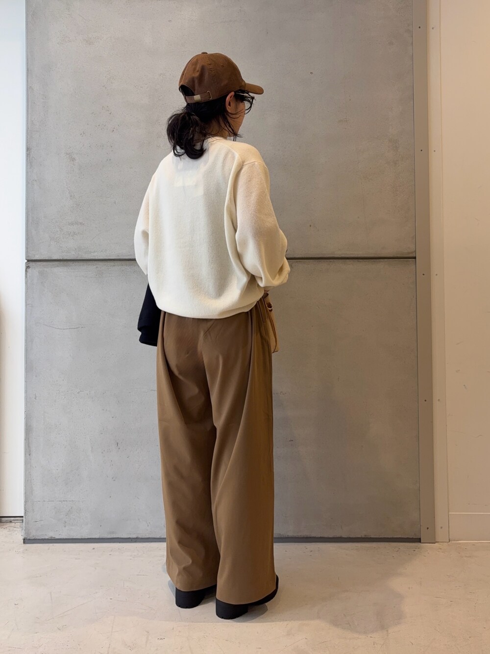 ブラウン系のブーツ、ホワイト系のニット/セーター、イエロー系のその他パンツを着用したレディースの冬コーディネートの8枚目の写真