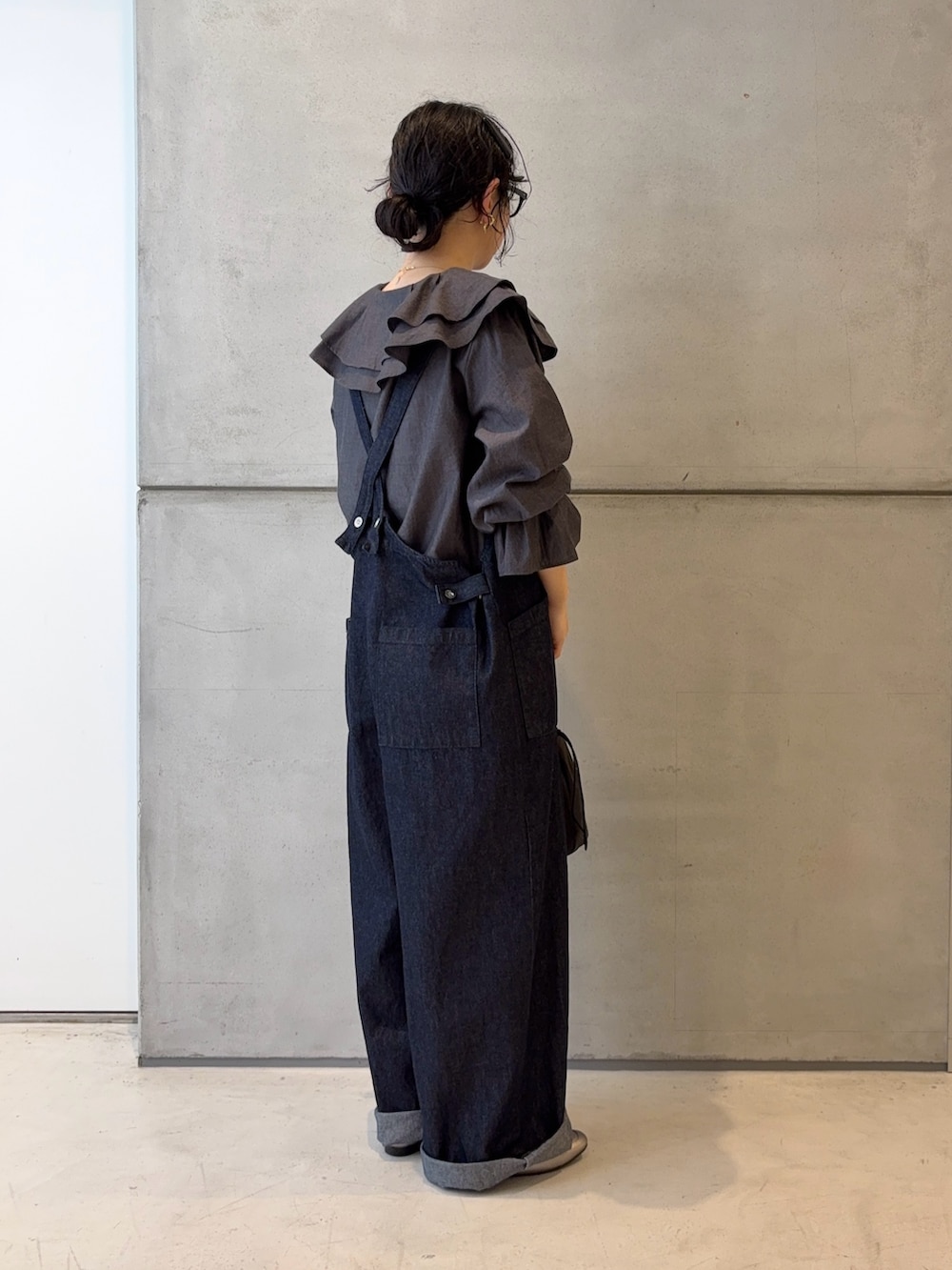 ブルー系のサロペット/オーバーオール、ブルー系のシャツ/ブラウス、ブラック系のバッグを着用したレディースの冬コーディネートの4枚目の写真