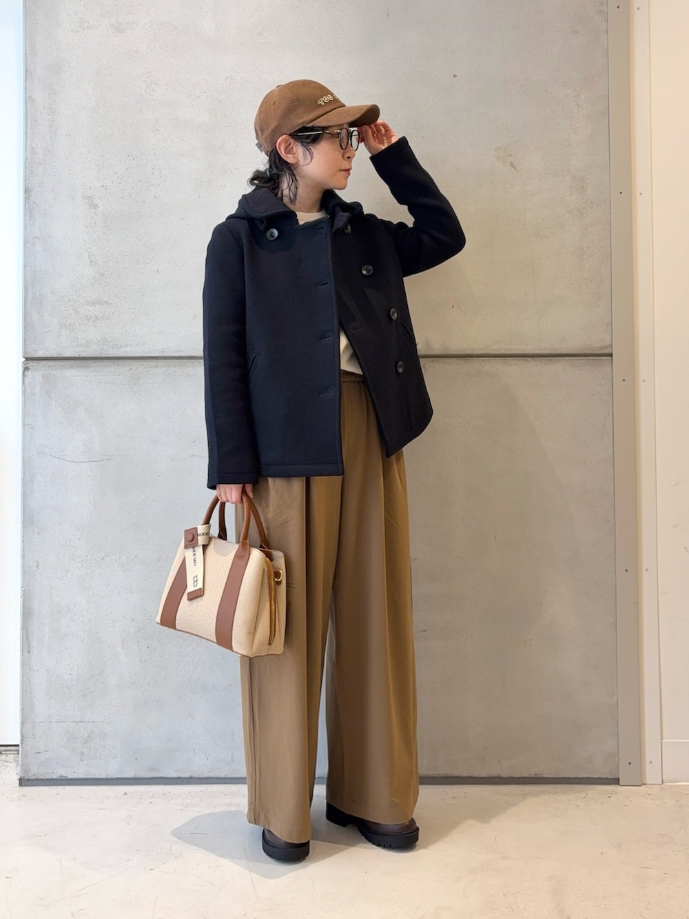 ブラウン系のブーツ、ホワイト系のニット/セーター、イエロー系のその他パンツを着用したレディースの冬コーディネートの2枚目の写真