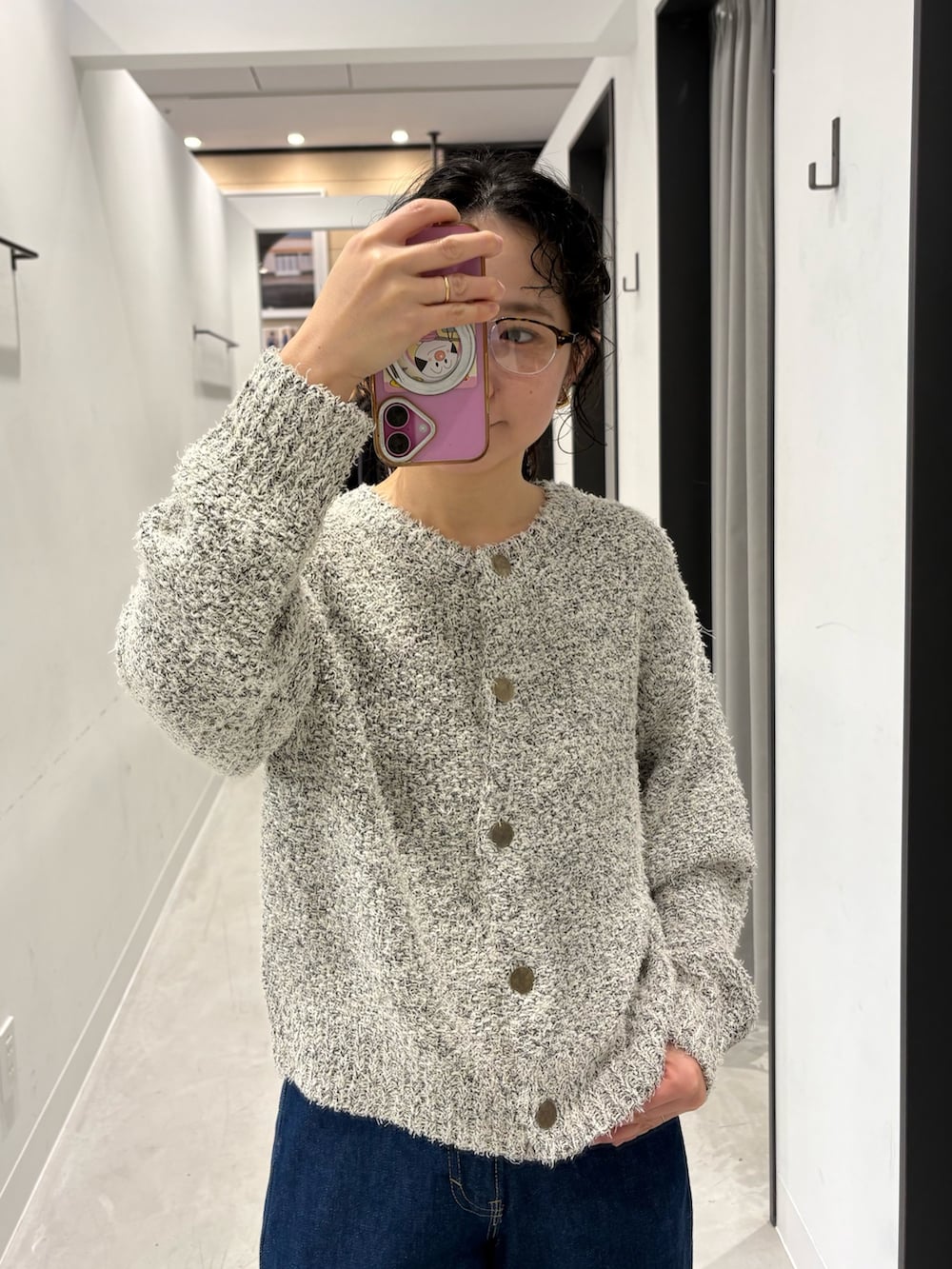 ホワイト系のカーディガン/ボレロ、ブルー系のデニムパンツ、シルバー系のショルダーバッグを着用したレディースの冬コーディネートの5枚目の写真