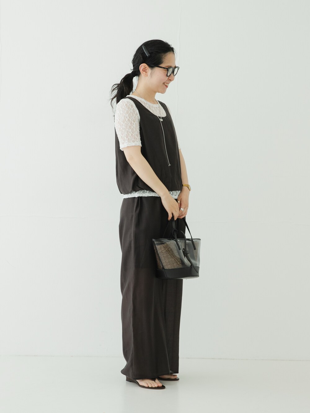グレー系のその他パンツ、ブラウン系のサンダル、ブラック系のかごバッグを着用したレディースの夏コーディネートの3枚目の写真