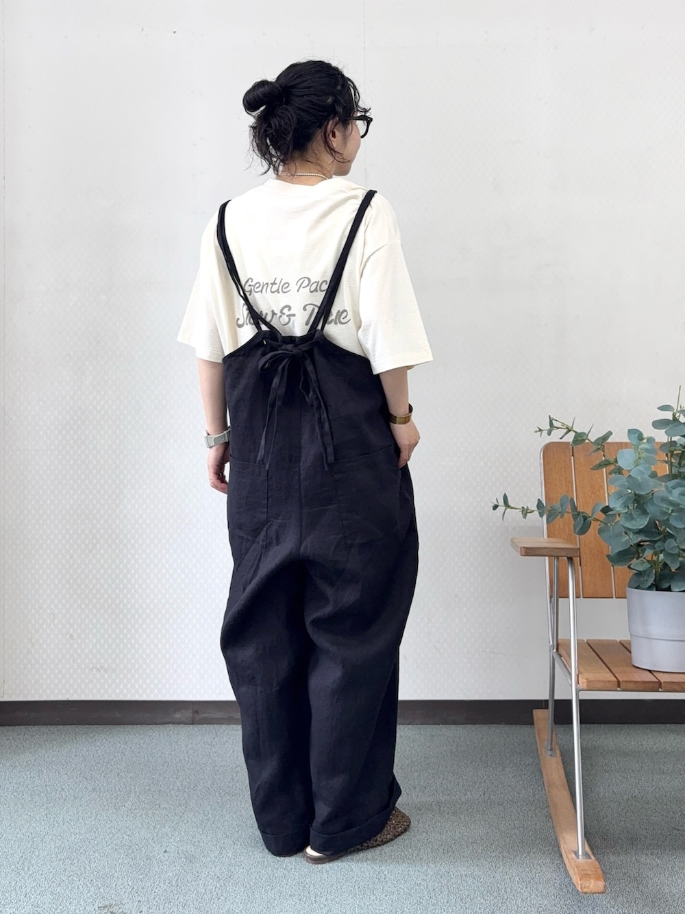 ブラウン系のサンダル、ブラック系のサロペット/オーバーオール、ベージュ系のTシャツ/カットソーを着用したレディースの春コーディネートの3枚目の写真