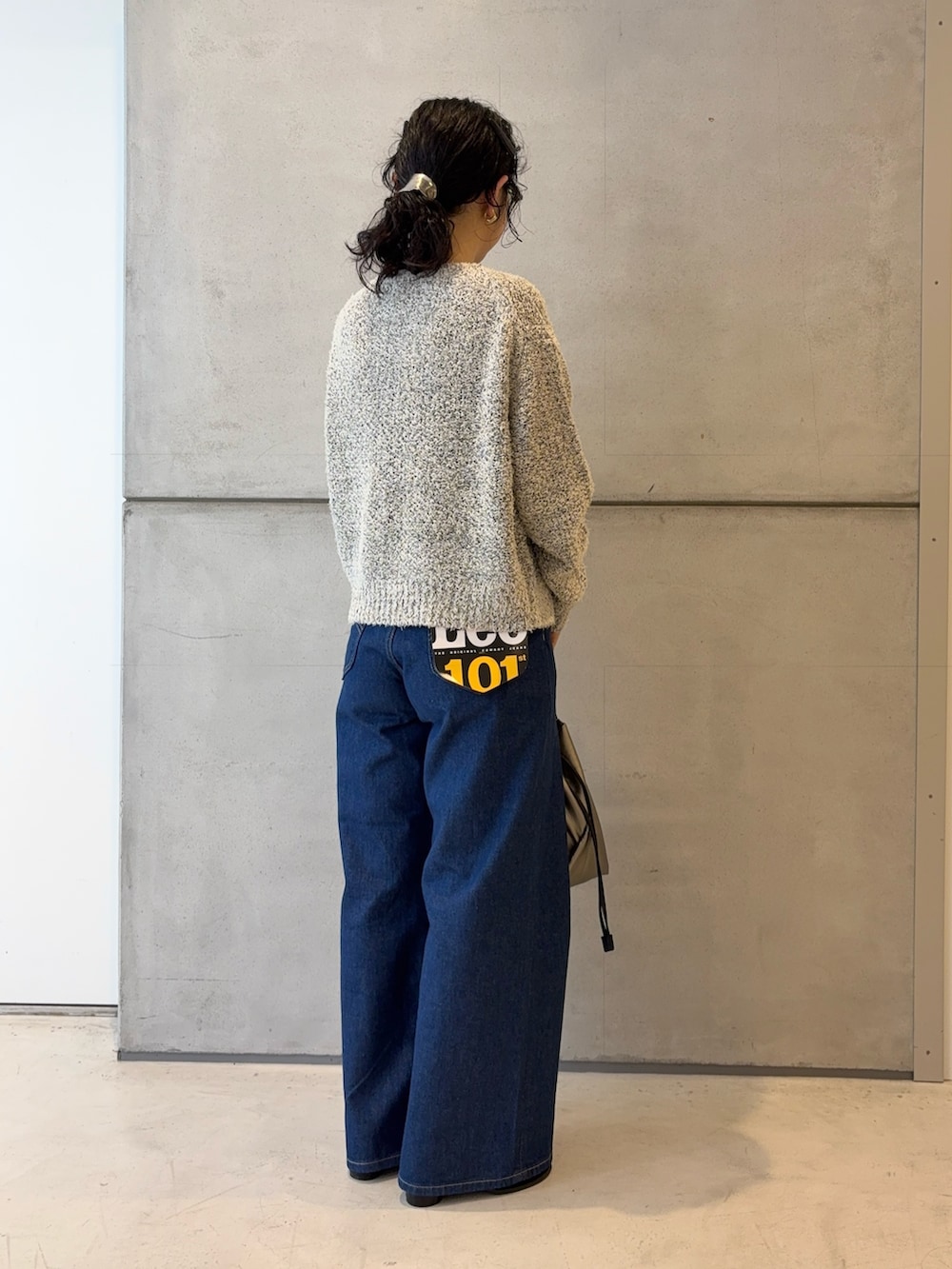 ホワイト系のカーディガン/ボレロ、ブルー系のデニムパンツ、シルバー系のショルダーバッグを着用したレディースの冬コーディネートの4枚目の写真