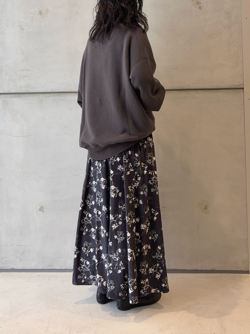 グレー系のスウェット、ブラック系のハンドバッグ、ブラック系のパンプスを着用したレディースの秋コーディネートの4枚目の写真