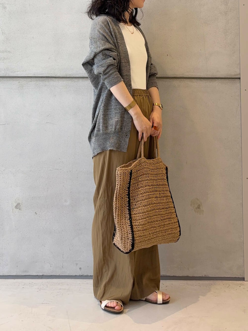 グレー系のカーディガン/ボレロ、ベージュ系のトートバッグ、ホワイト系のタンクトップを着用したレディースの夏コーディネートの4枚目の写真