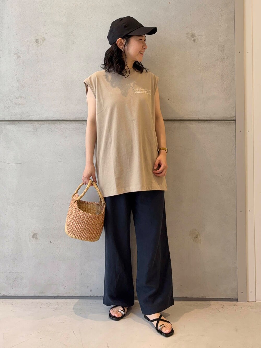 オレンジ系のショルダーバッグ、ベージュ系のTシャツ/カットソー、ブルー系のその他パンツを着用したレディースの夏コーディネートの2枚目の写真