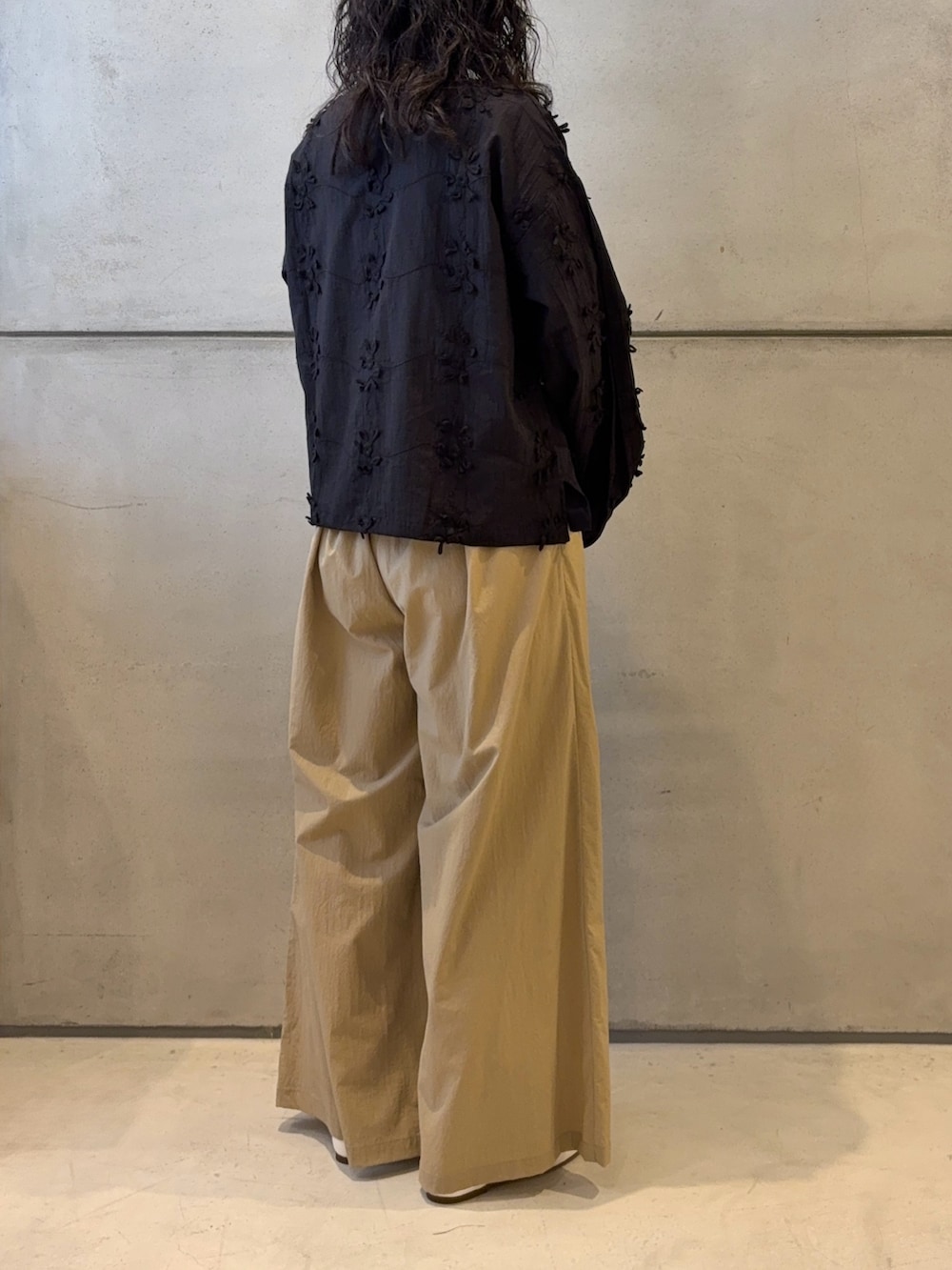 ベージュ系のその他パンツ、ブラック系のトートバッグ、ホワイト系のスニーカーを着用したレディースの春コーディネートの4枚目の写真