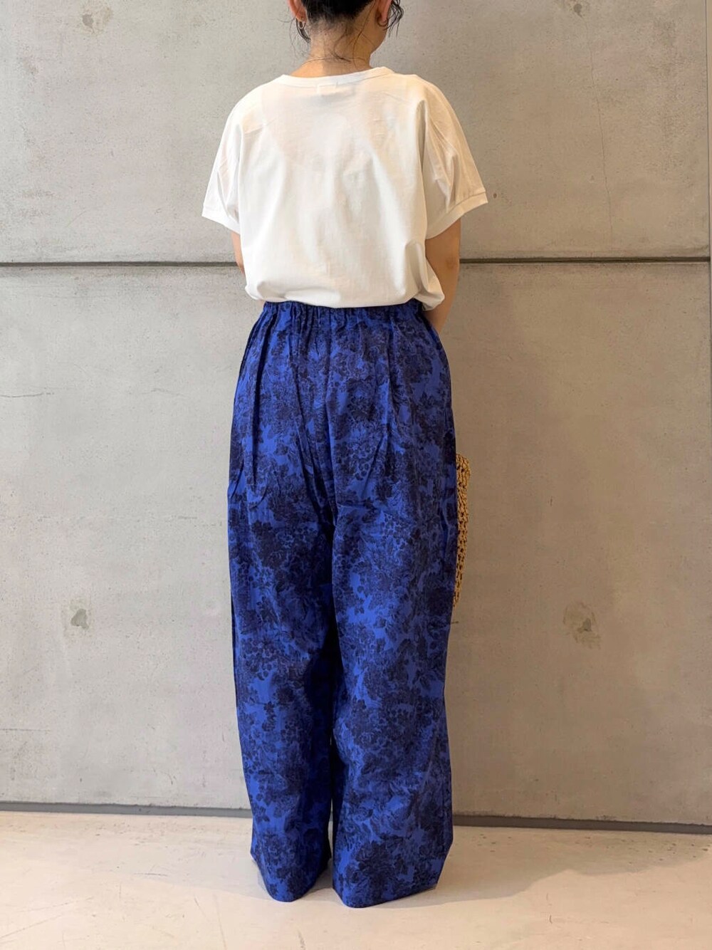 ベージュ系のトートバッグ、ブラック系のパンプス、ホワイト系のTシャツ/カットソーを着用したレディースの夏コーディネートの4枚目の写真